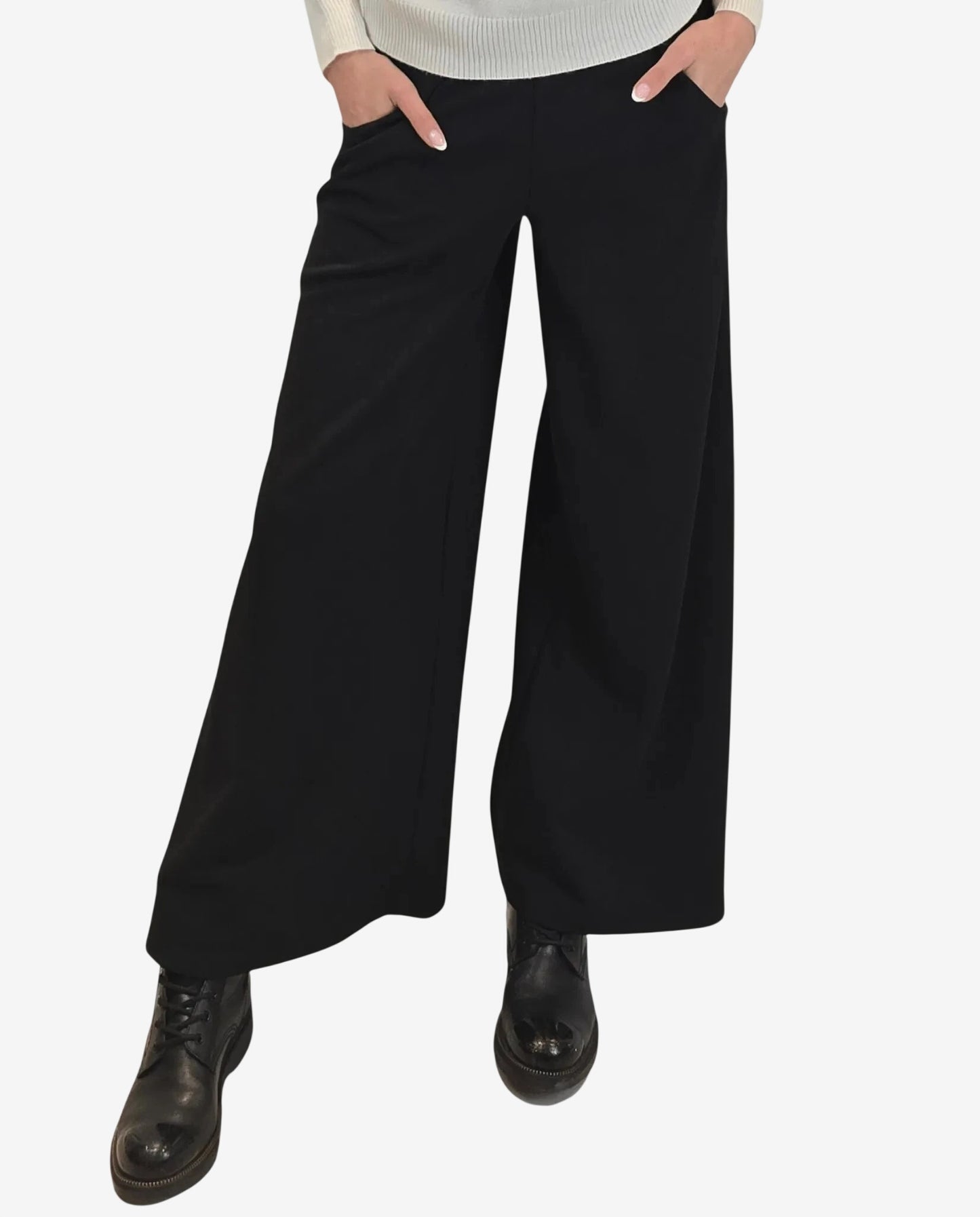 A person wears black wide-leg trousers paired with black lace-up boots.