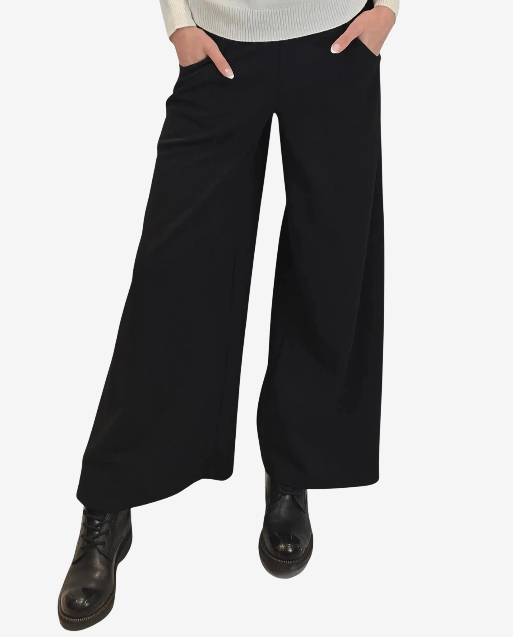 A person wears black wide-leg trousers paired with black lace-up boots.