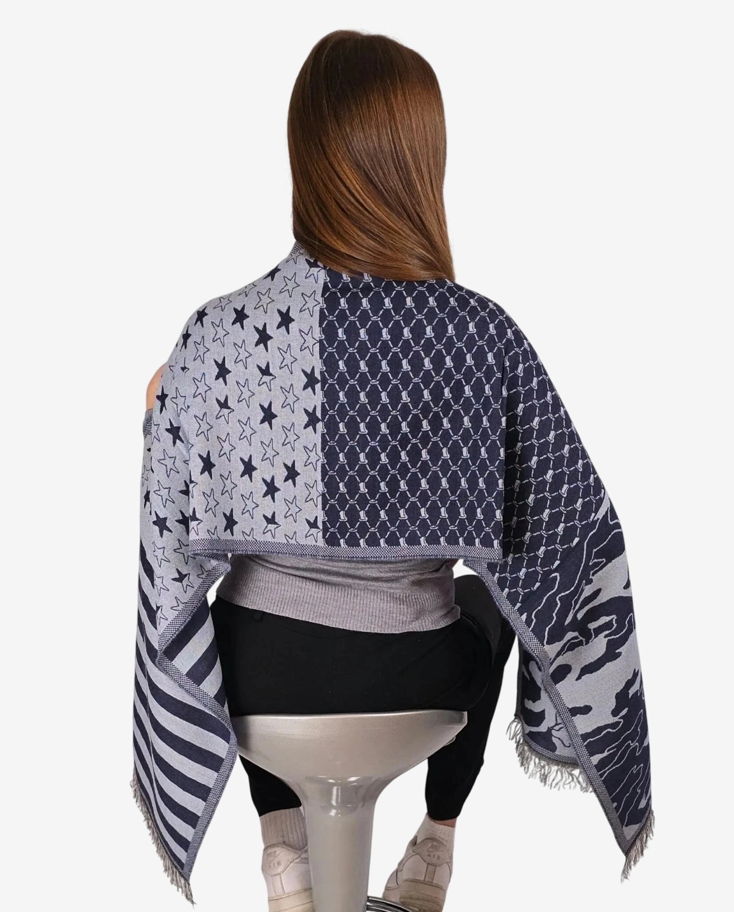 Sciarpa invernale da donna con fantasia a stelle, strisce e motivi geometrici nei toni del blu.