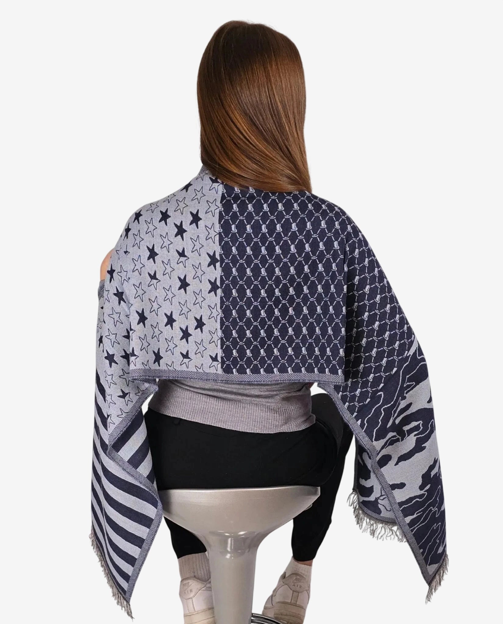 Sciarpa invernale da donna con fantasia a stelle, strisce e motivi geometrici nei toni del blu.