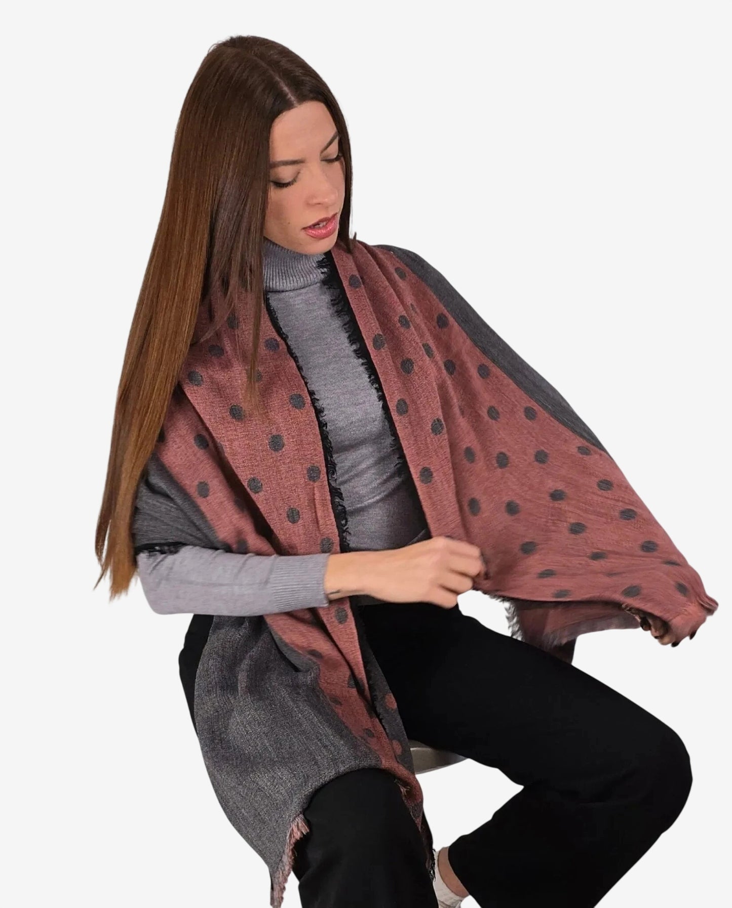 Modella indossa una sciarpa invernale in lana e alpaca color ruggine con pois scuri.