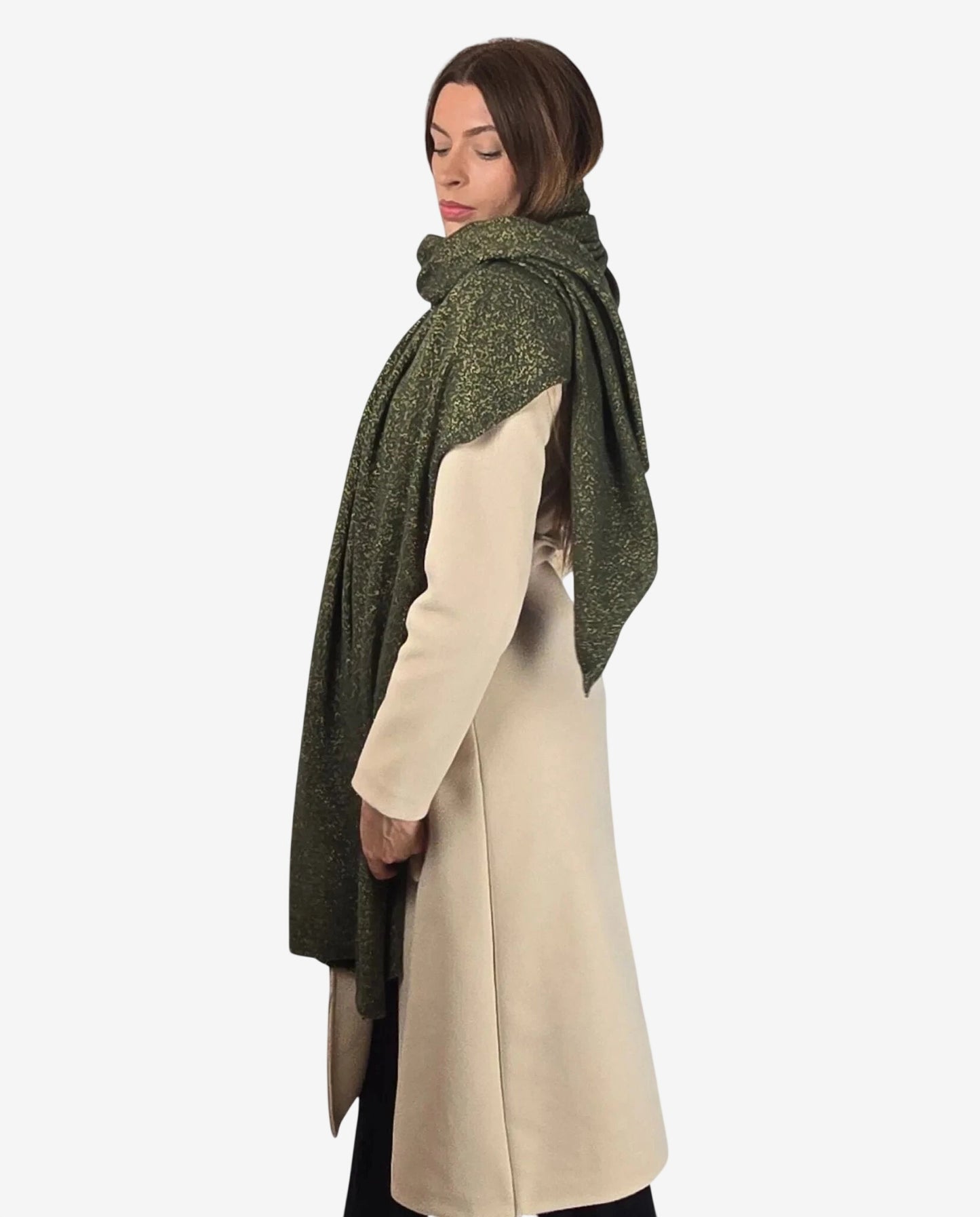 Modella indossa una sciarpa verde in lurex, cachemire e lana merino sopra un cappotto beige.