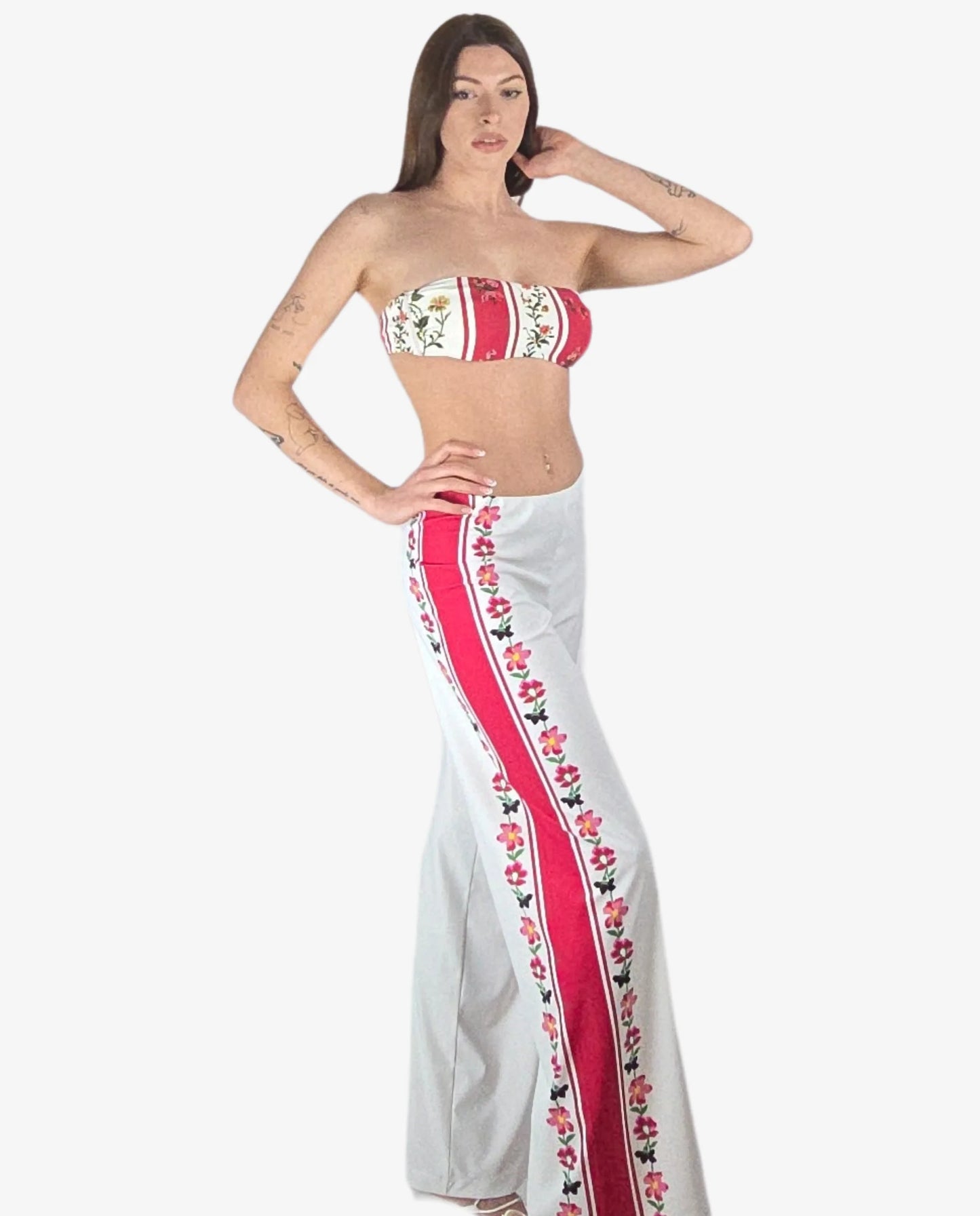 Pantalone palazzo bianco in lycra con bande laterali rosse a motivi floreali.