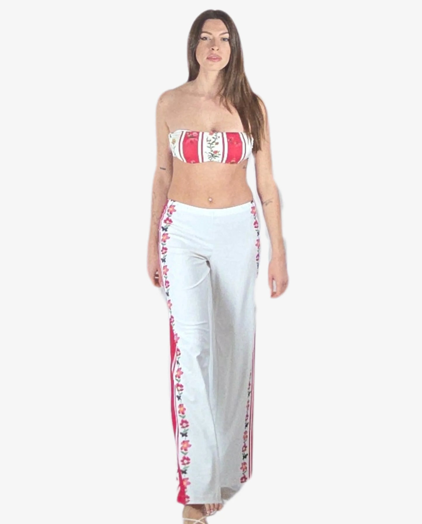Pantalone palazzo bianco con bande laterali a righe rosse e motivi floreali.