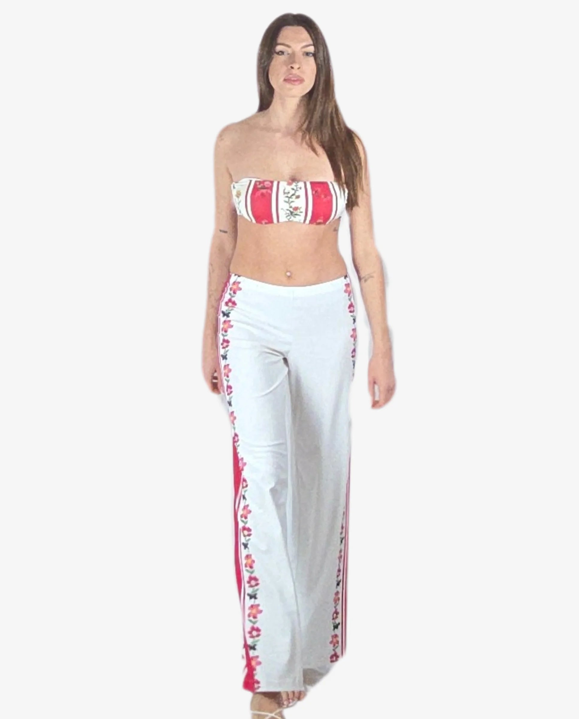 Pantalone palazzo bianco con bande laterali a righe rosse e motivi floreali.