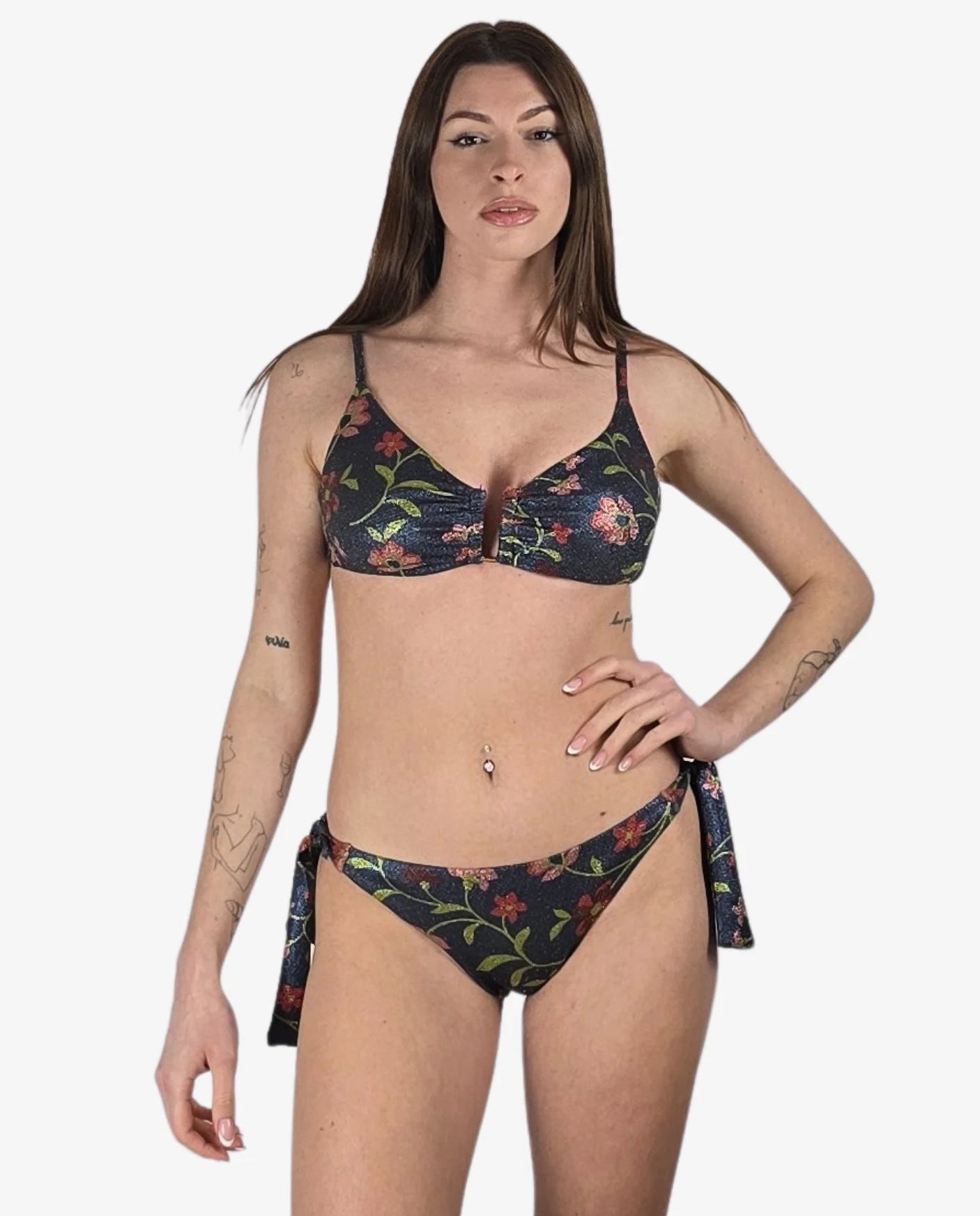 Modella che indossa un bikini a due pezzi in tessuto lurex scuro con stampa floreale colorata.