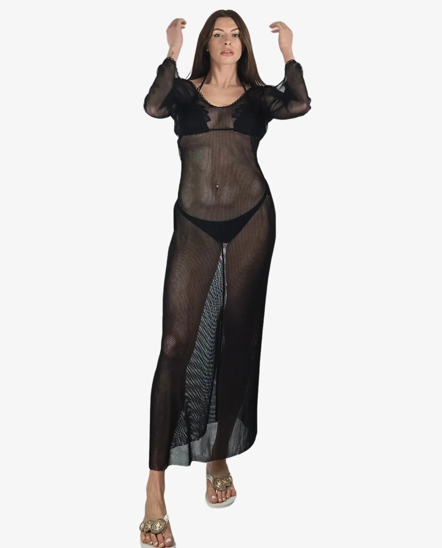 Modella indossa un abito lungo a rete nero a maniche lunghe sopra un bikini coordinato.