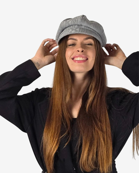 Donna che indossa un cappello grigio con visiera dal design moderno e raffinato.