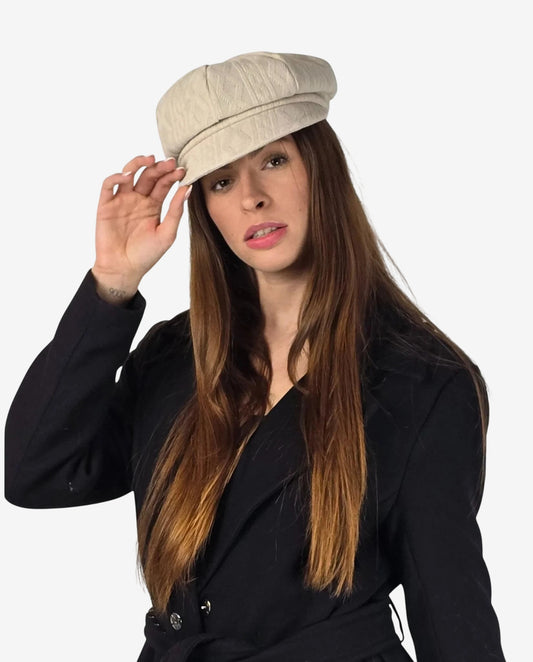 Cappello da donna in lana beige con lavorazione a treccia e visiera.
