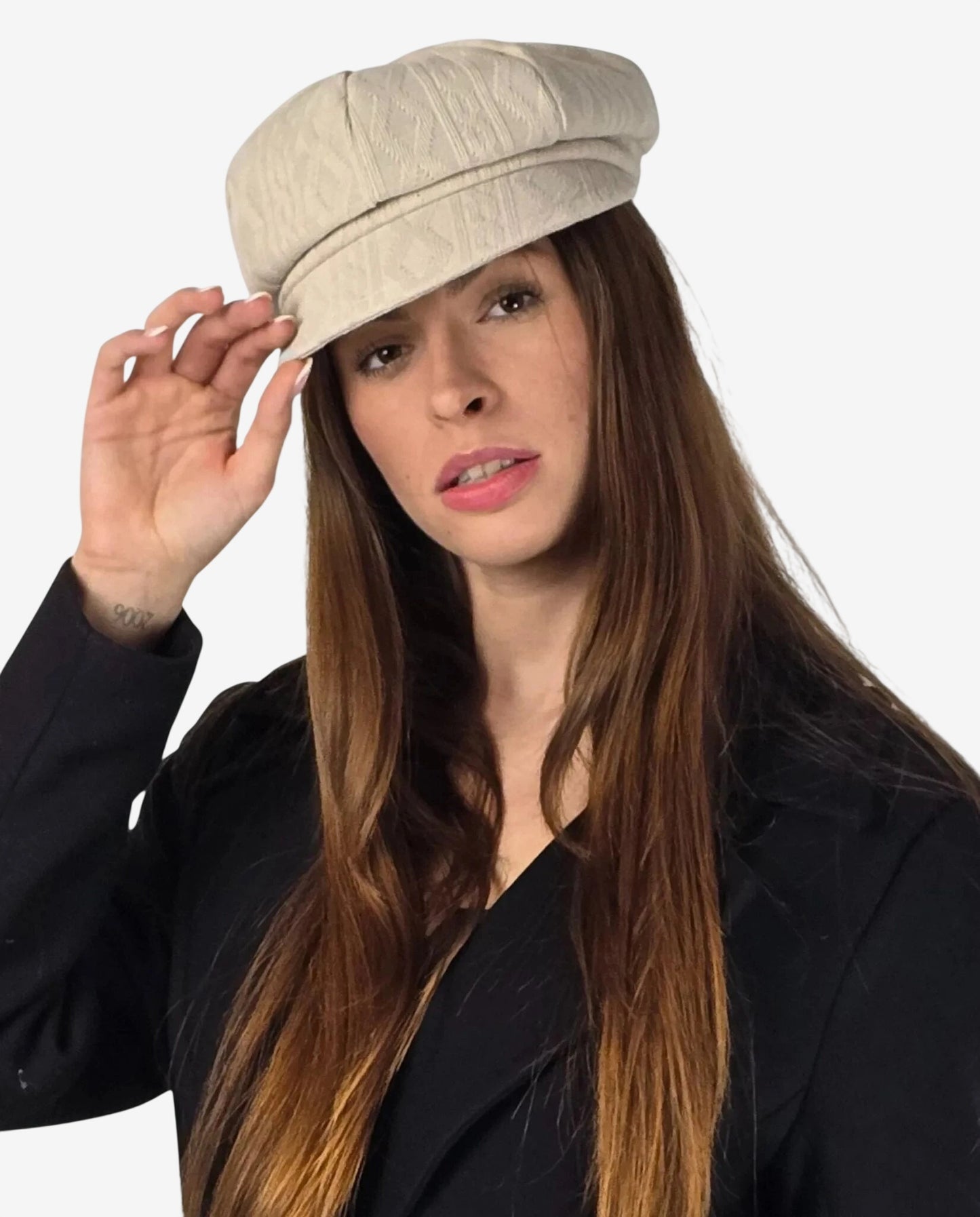 Cappello da donna in lana beige con lavorazione a treccia indossato da una modella.