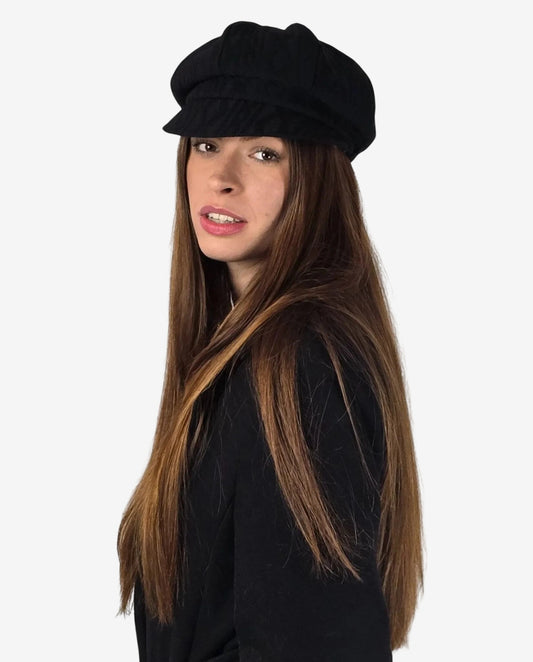 Donna che indossa un cappello nero in lana intrecciata dal design classico.