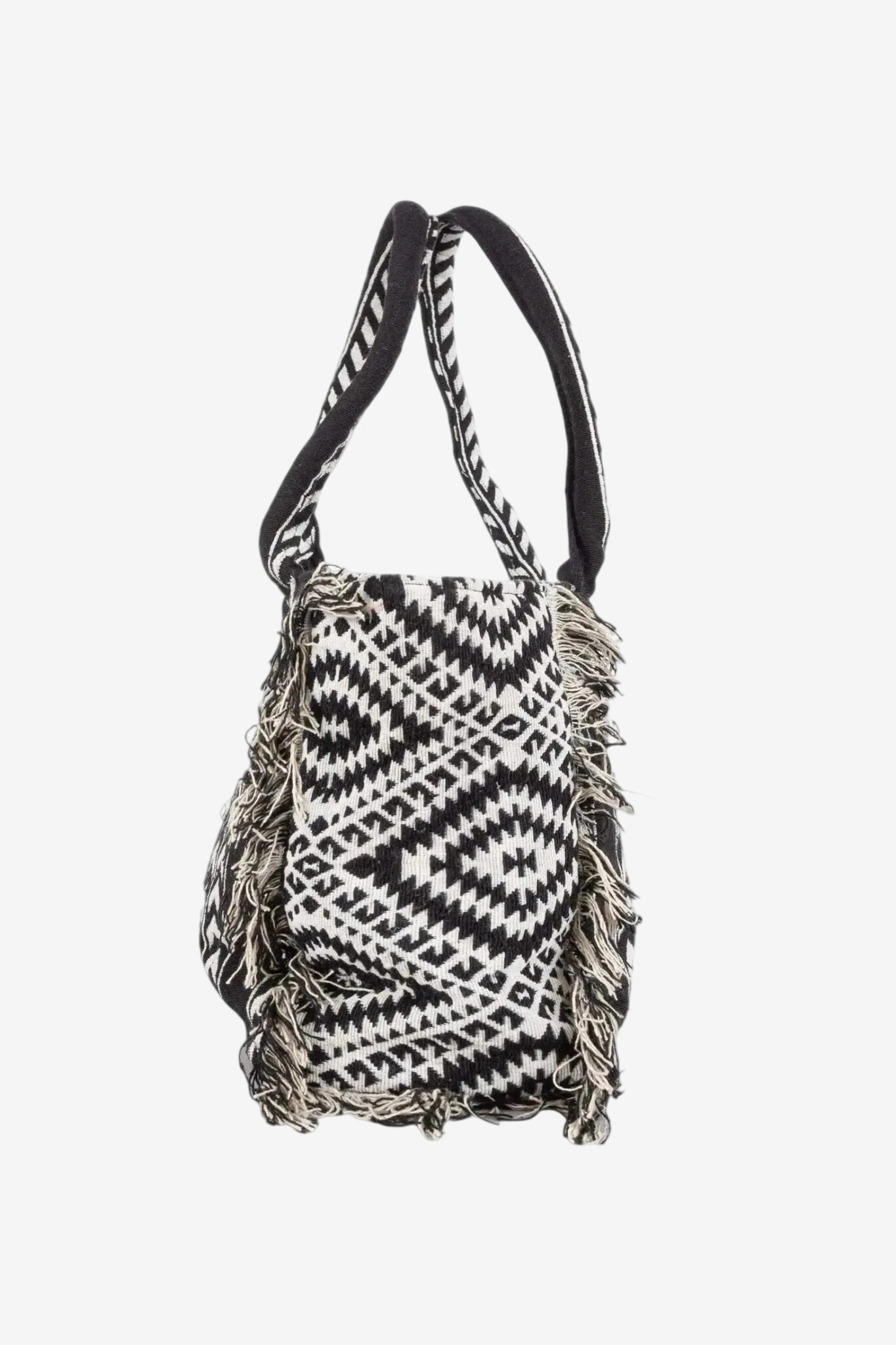 Borsetta a mano con fantasia etnica in bianco e nero e frange decorative sui lati.