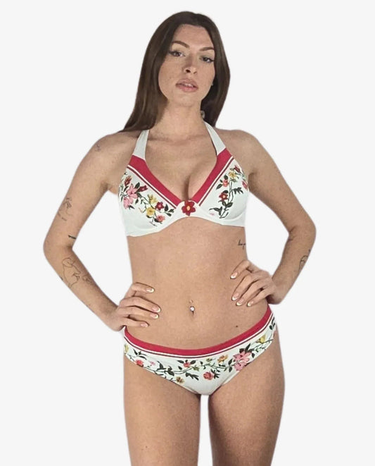 Bikini a ferretto bianco con stampa floreale multicolore e bordi rossi a contrasto.