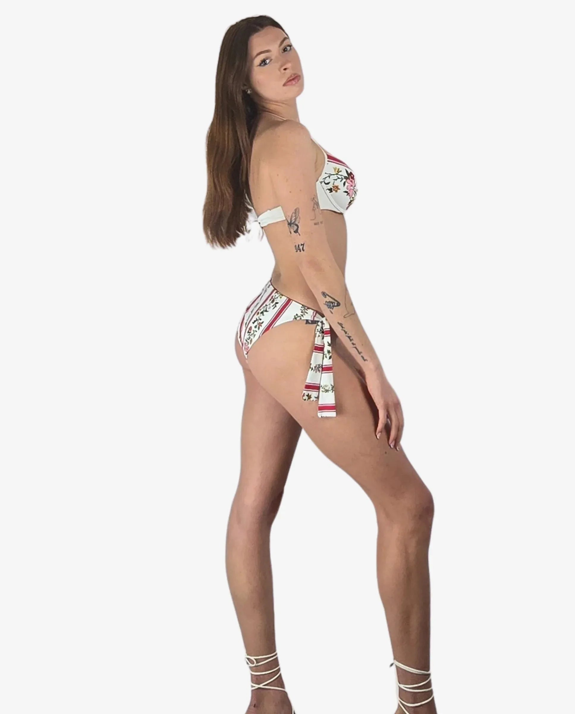 Bikini push up con righe rosse e fiori su fondo bianco, dotato di slip con laccetti laterali.