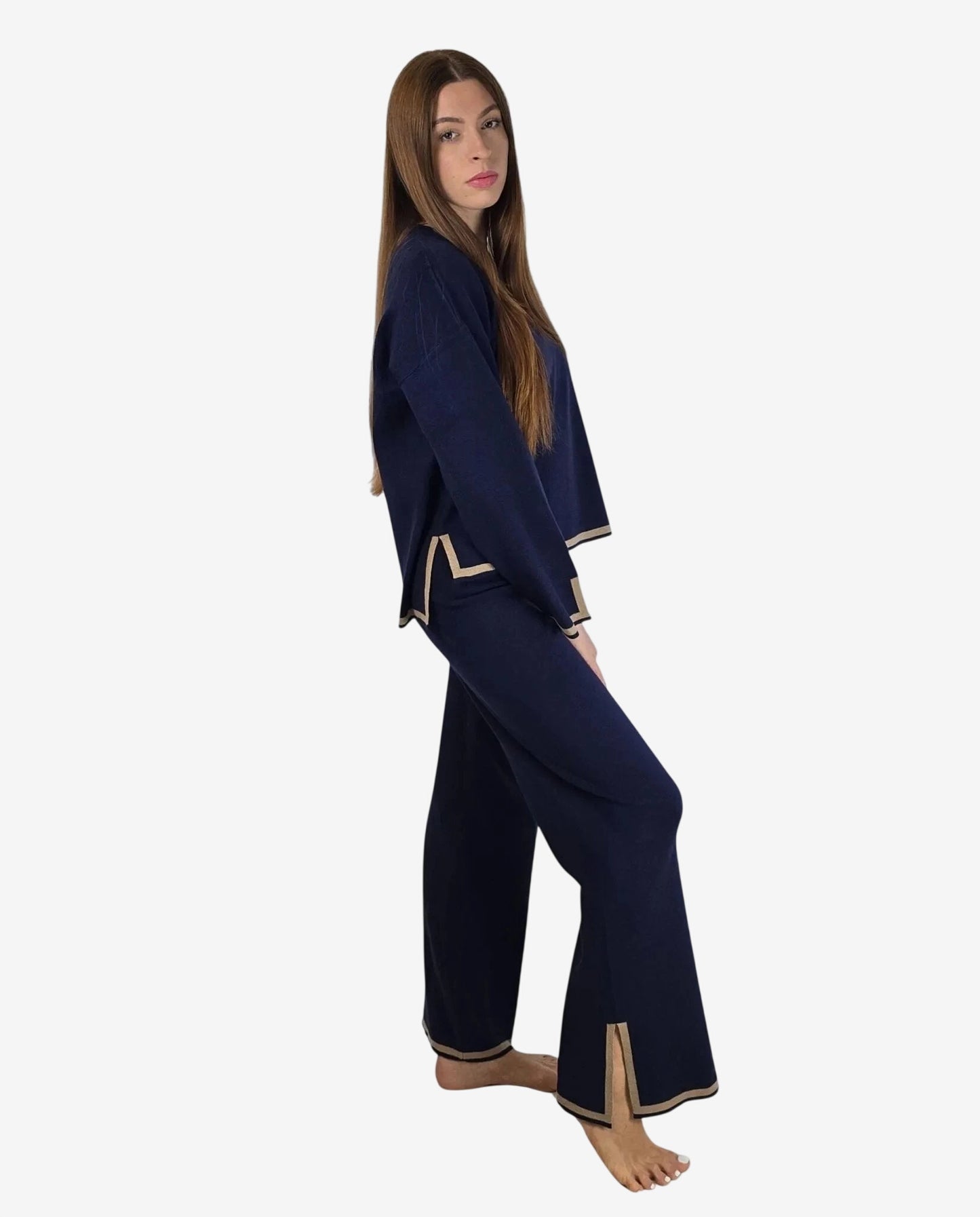 Modella indossa un completo in maglia blu notte con profili color cammello.