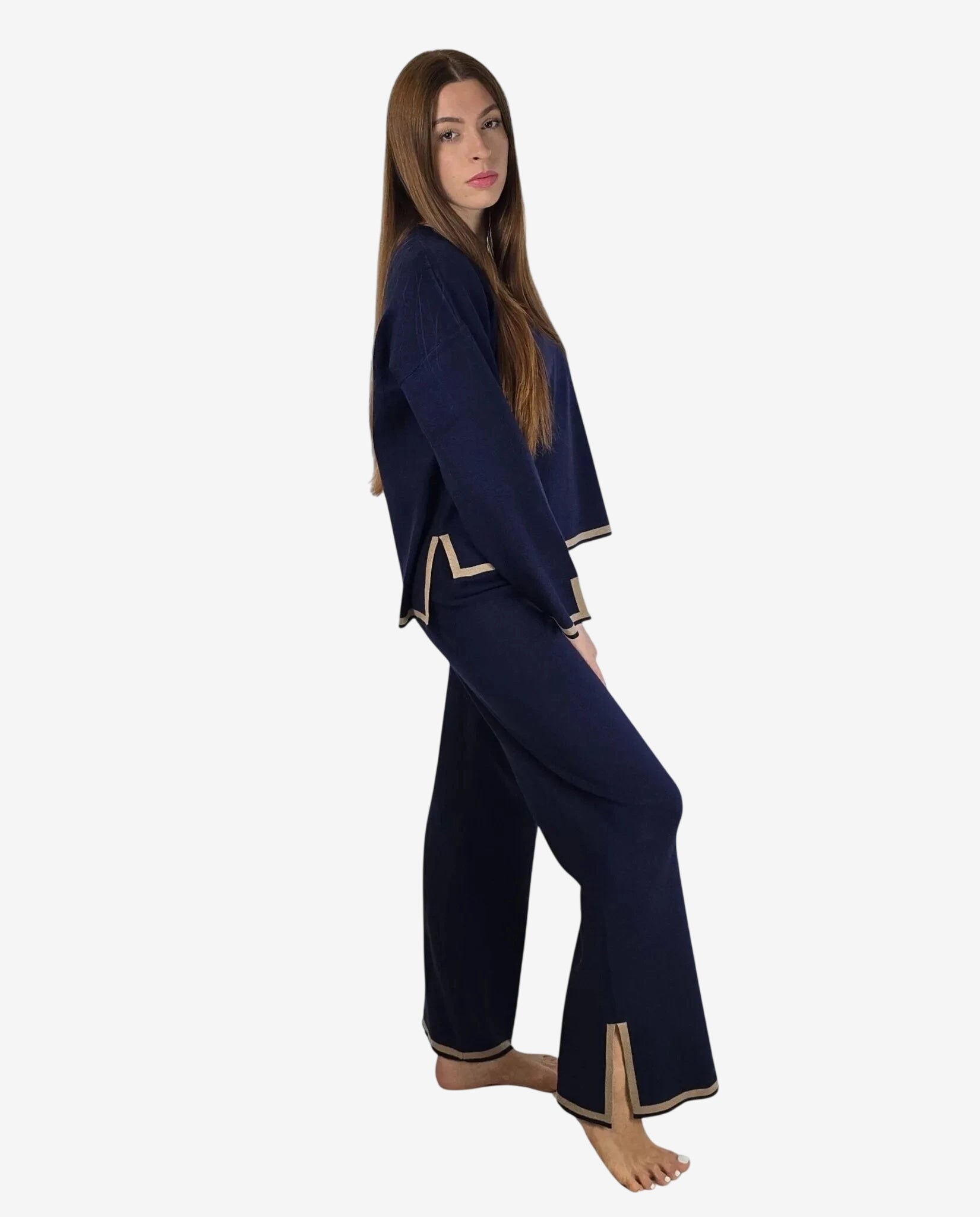 Modella indossa un completo in maglia blu notte con profili color cammello.