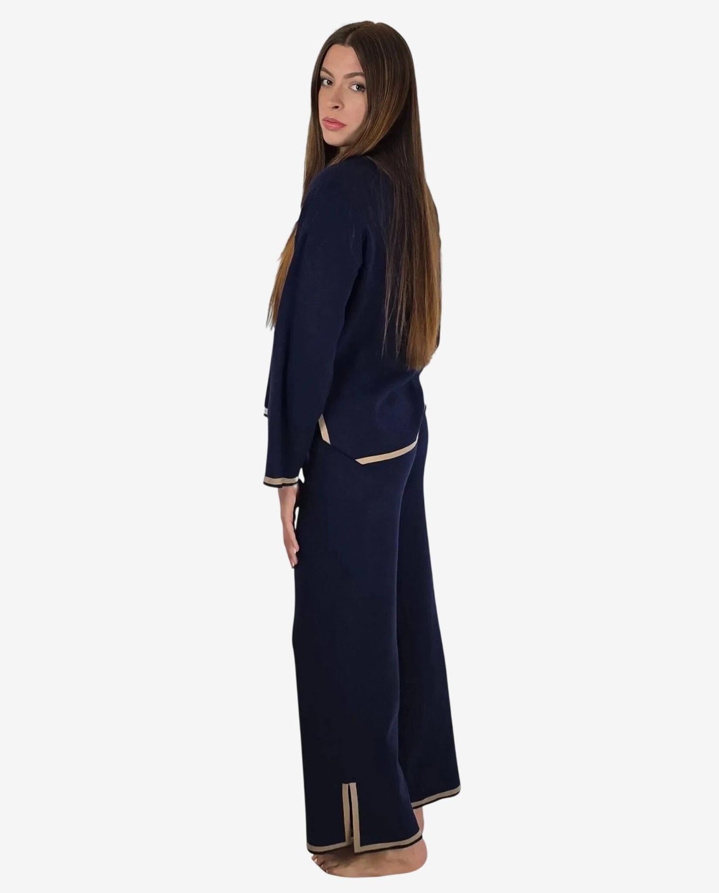 Modella indossa un completo in maglia blu notte con profili color cammello.