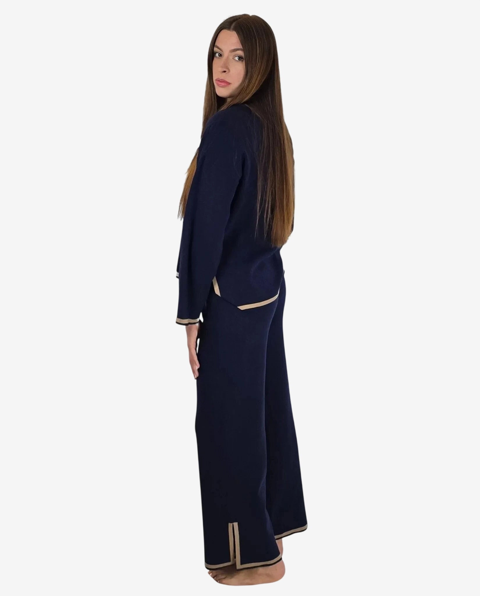 Modella indossa un completo in maglia blu notte con profili color cammello.