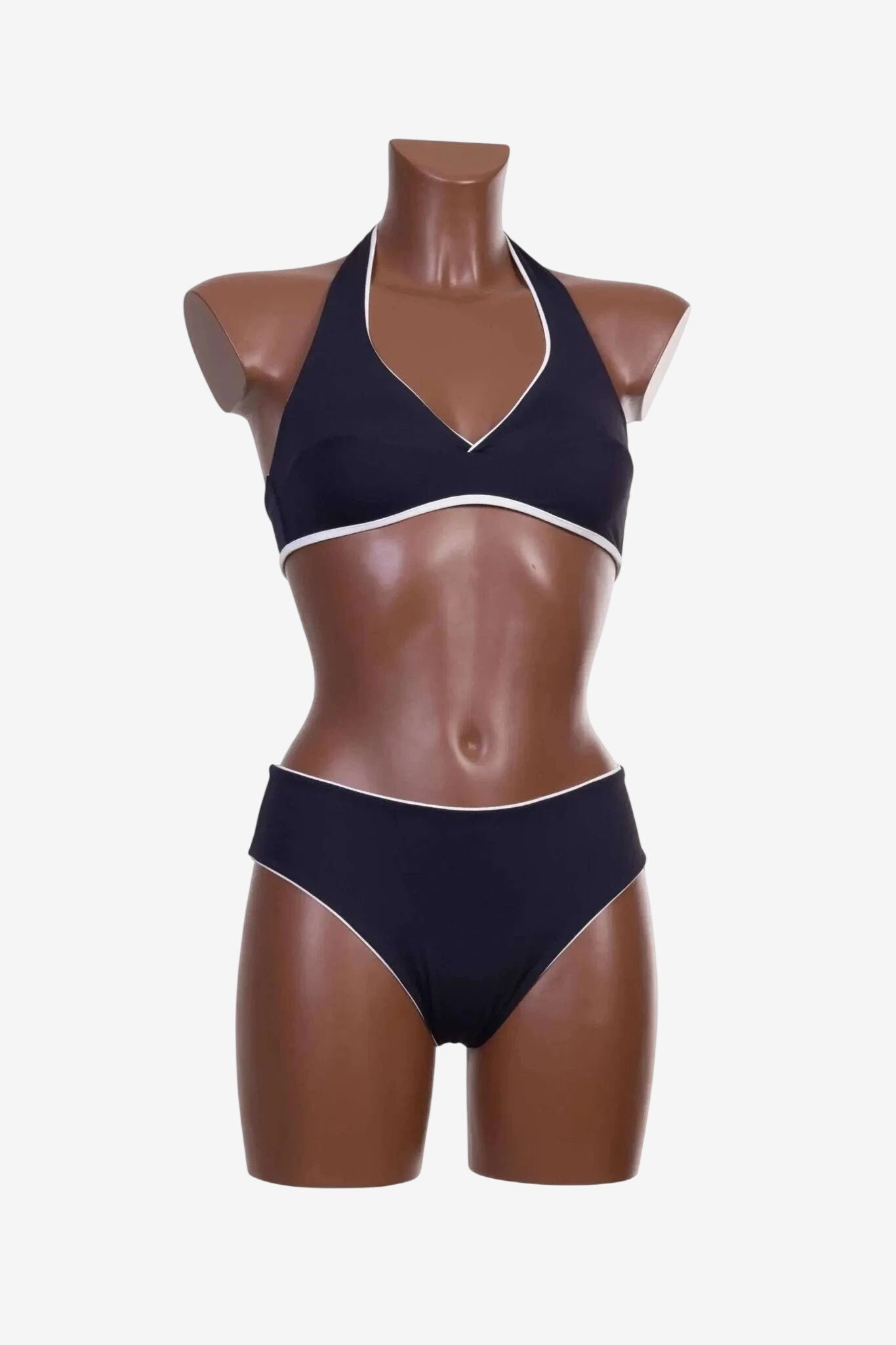 Bikini a triangolo nero con profili bianchi indossato da un manichino.