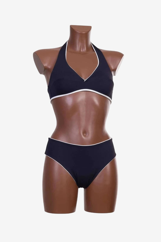 Bikini a triangolo nero con profili bianchi indossato da un manichino.