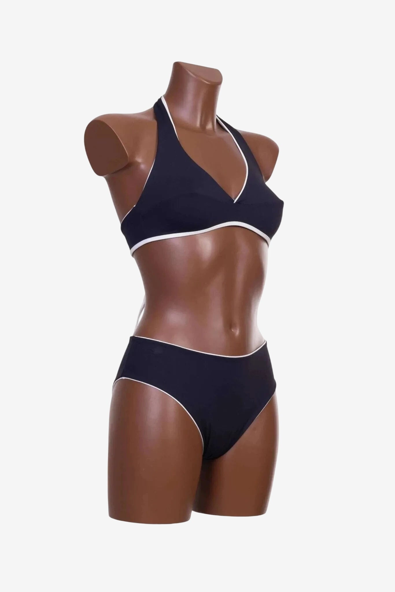 Bikini a triangolo nero con profili bianchi indossato da un manichino.