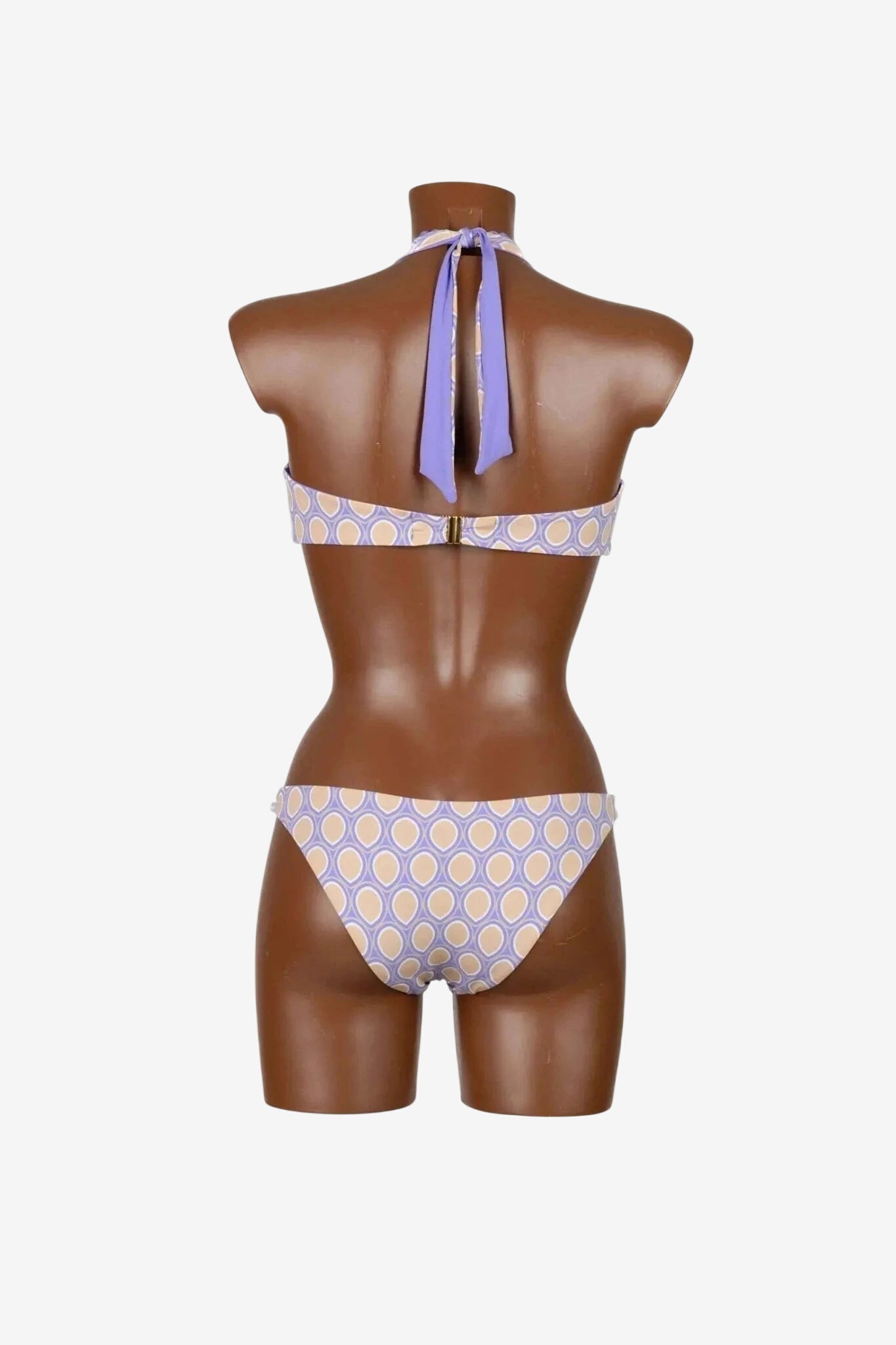 Vista posteriore di un bikini con motivo geometrico a cerchi color lavanda e beige su manichino.
