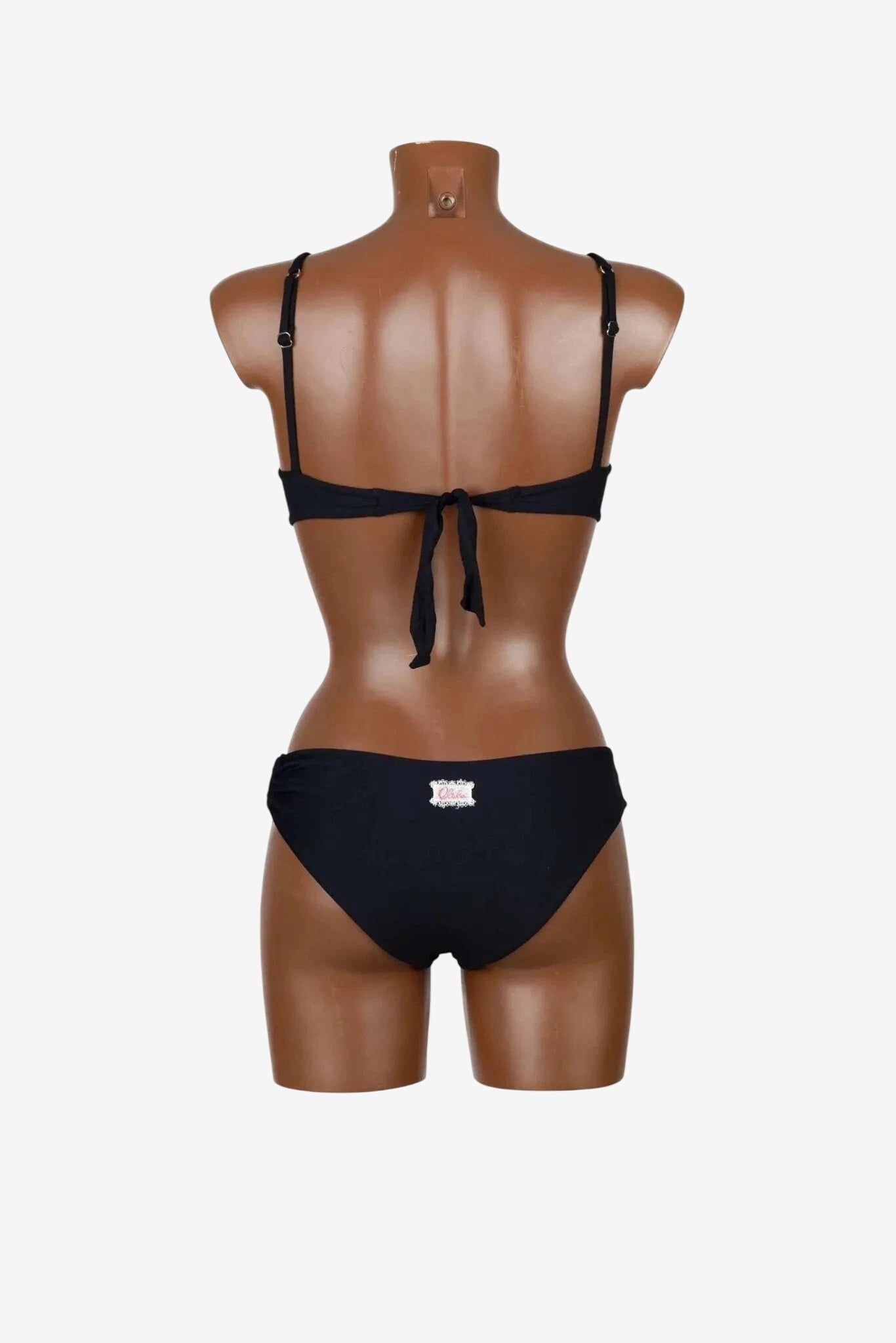 A black bikini bralette and matching bottoms shown from the back on a mannequin.