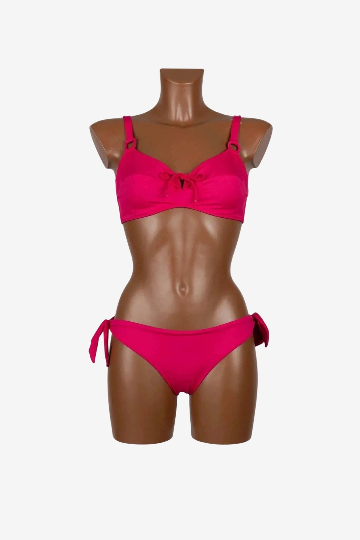 Bikini fucsia con reggiseno a ferretto e slip con fiocchi laterali su manichino.