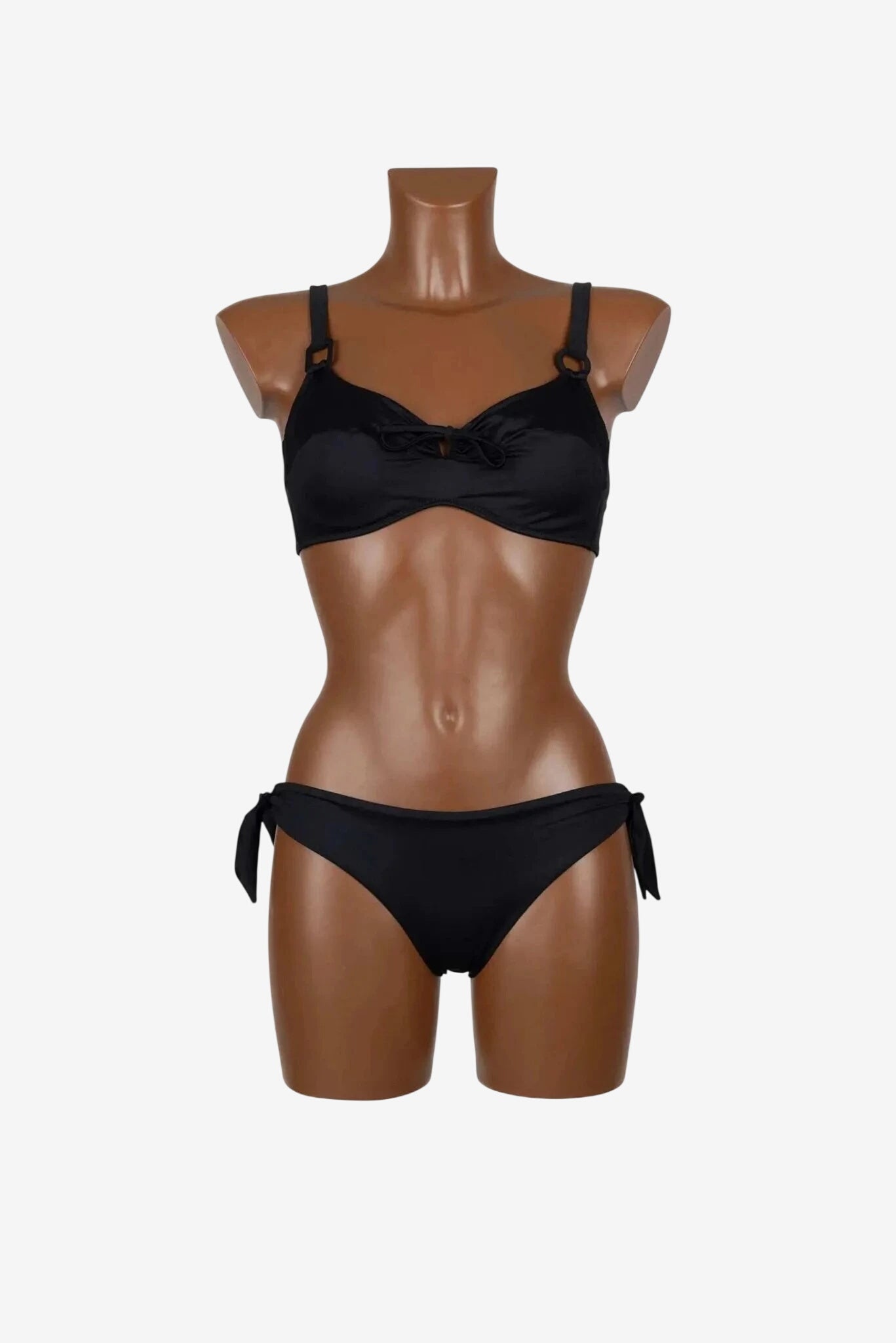Bikini nero con reggiseno a ferretto e slip con fiocchi laterali su manichino.