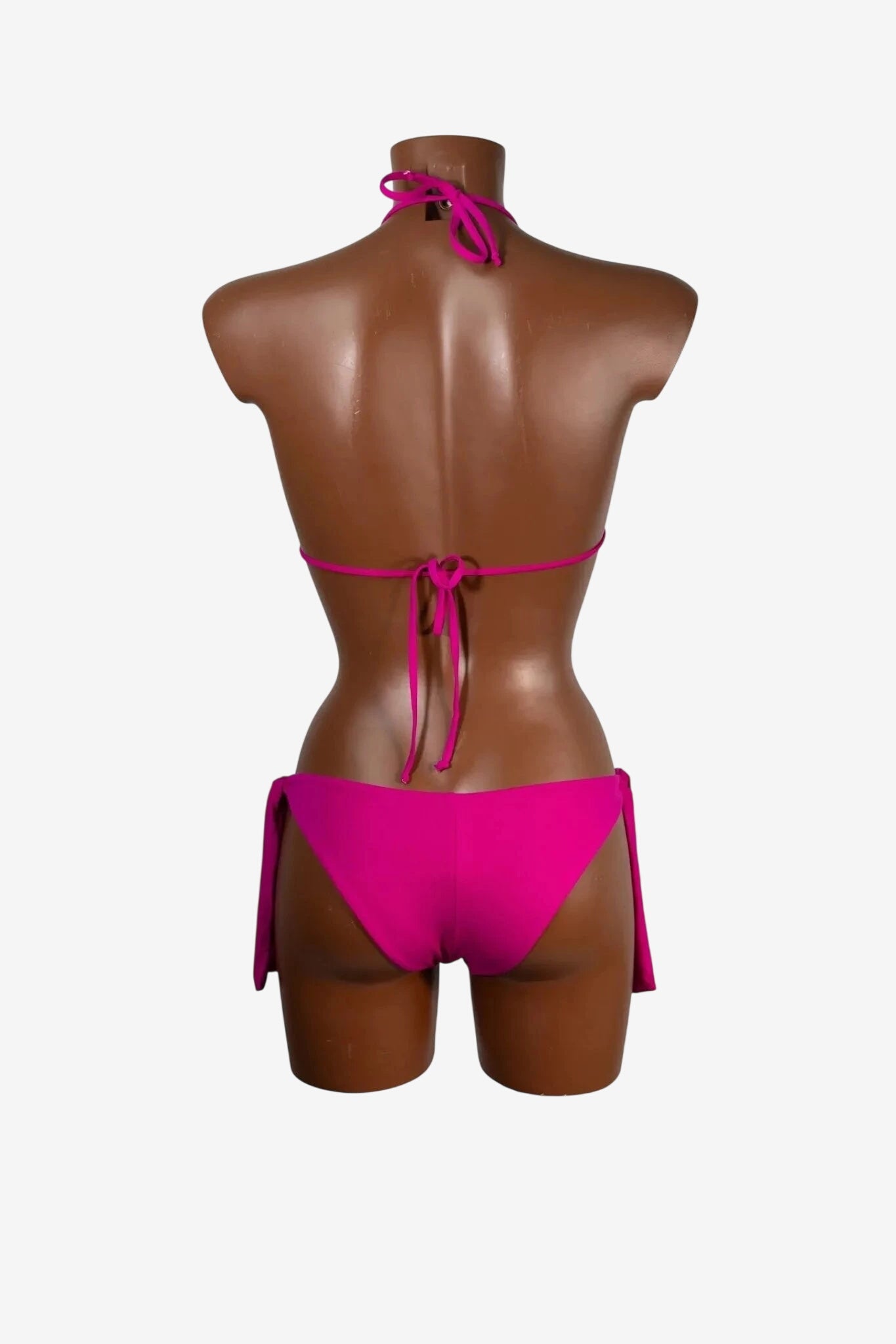 Bikini a triangolo fucsia con laccetti regolabili indossato da un manichino di spalle.