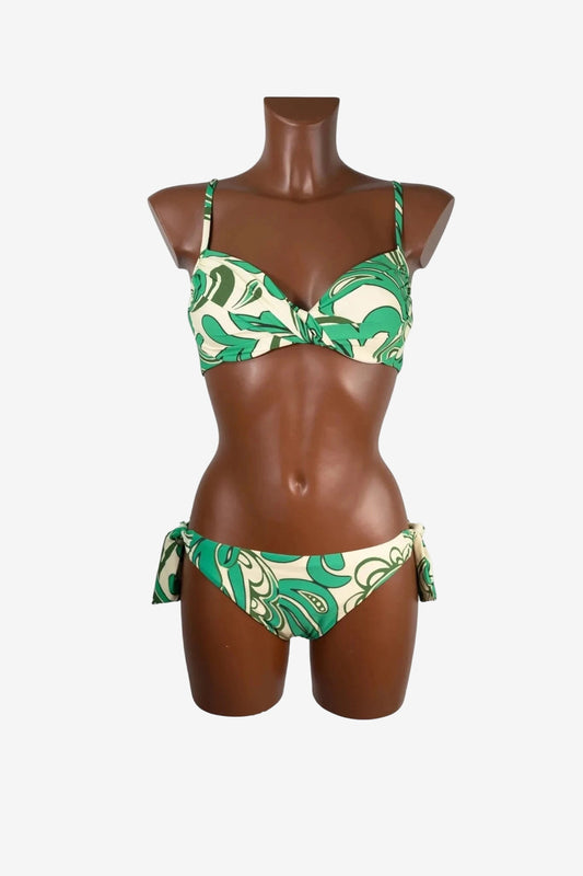 A green and cream patterned bikini set with a twisted top and side-tie bottoms on a mannequin.