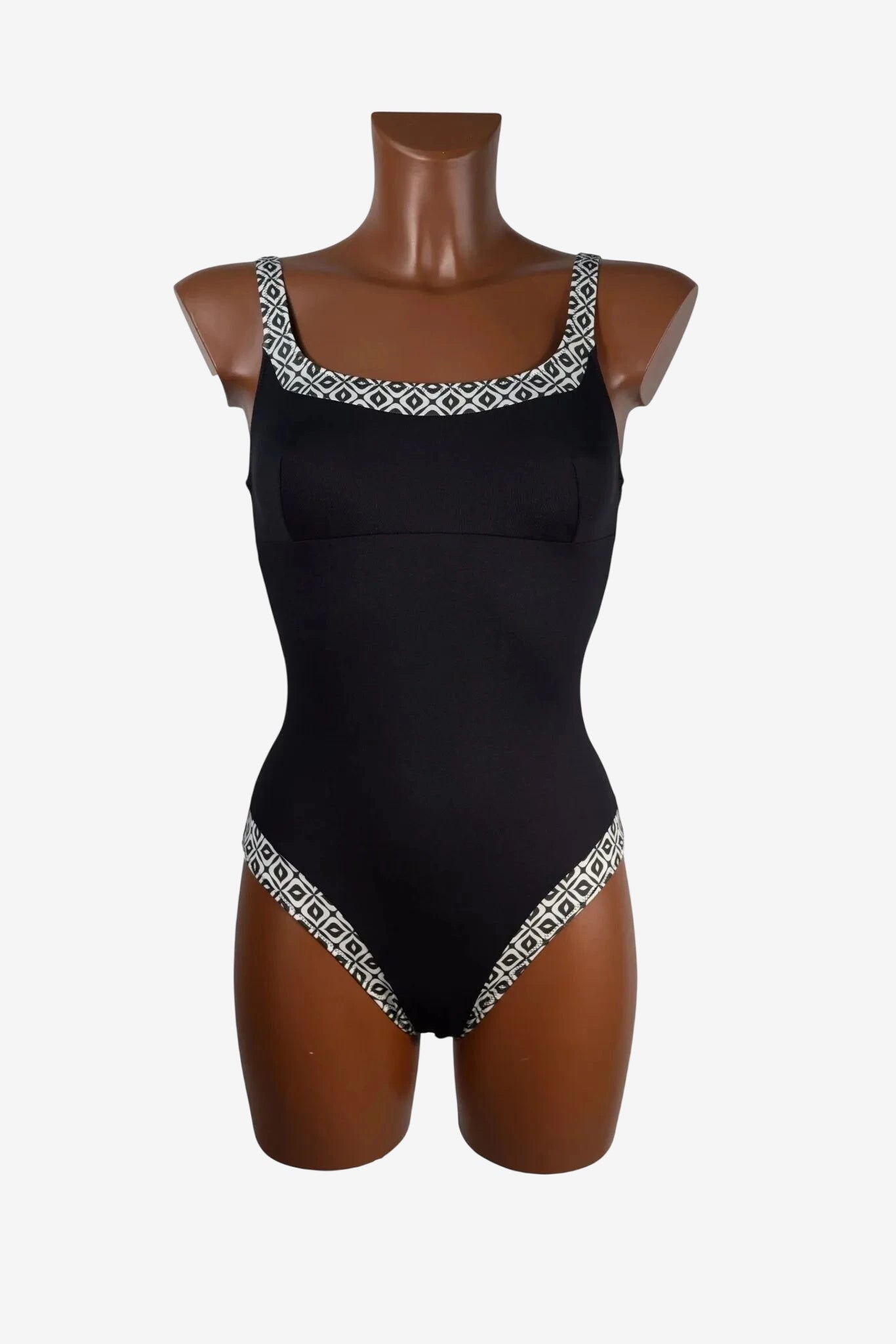 Costume intero nero con scollo e sgambatura decorati da un motivo geometrico bianco e nero.
