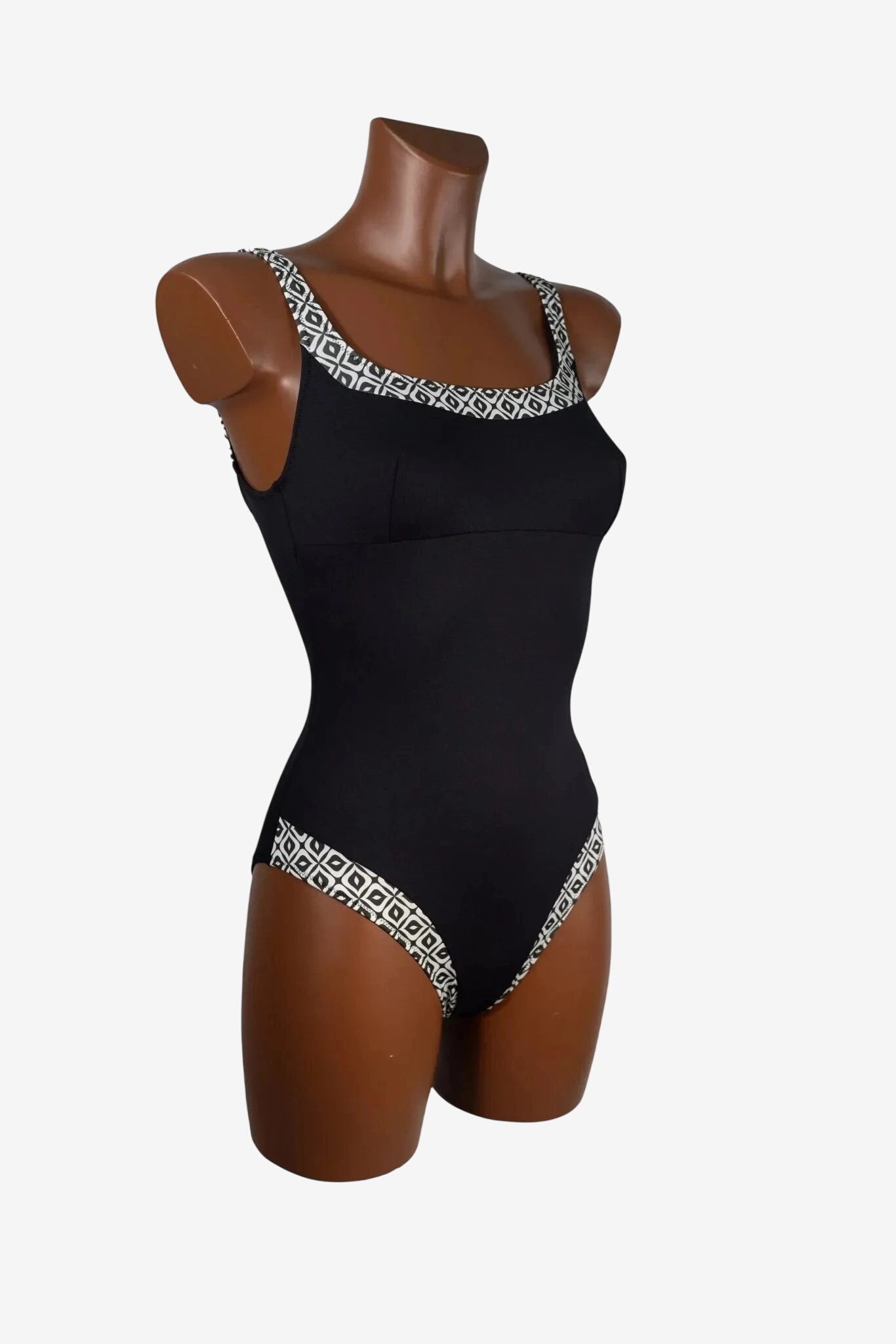 Costume intero nero con scollo e sgambatura decorati da un motivo geometrico bianco e nero.