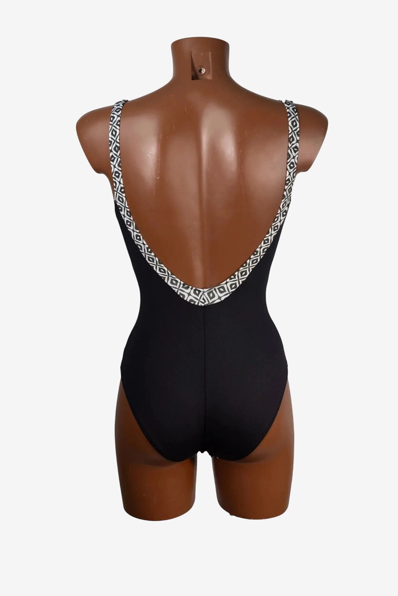 Costume intero nero con scollo profondo sulla schiena e bordi decorati da un motivo geometrico.