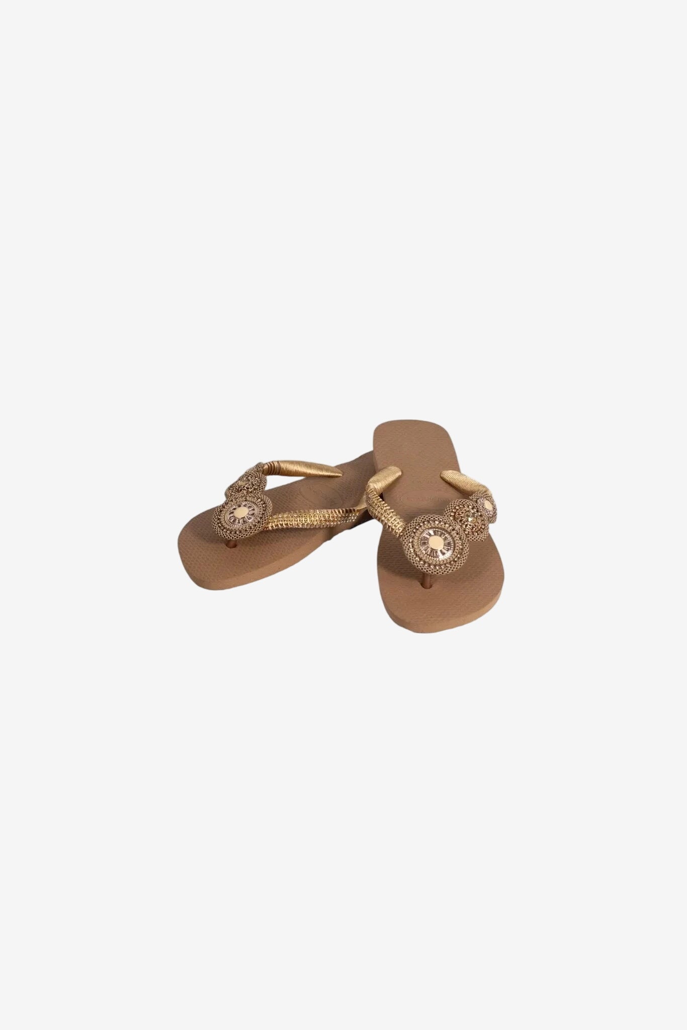 Infradito da donna color beige con cinturini decorati da dettagli dorati e pietre centrali.