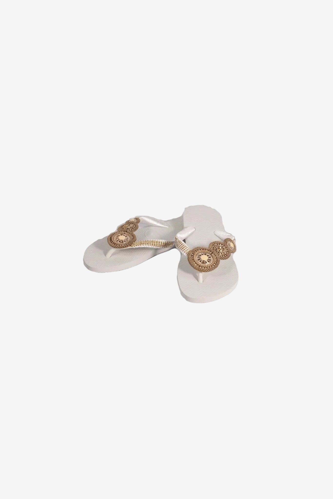 Infradito bianche da donna con decorazioni circolari dorate sui cinturini.
