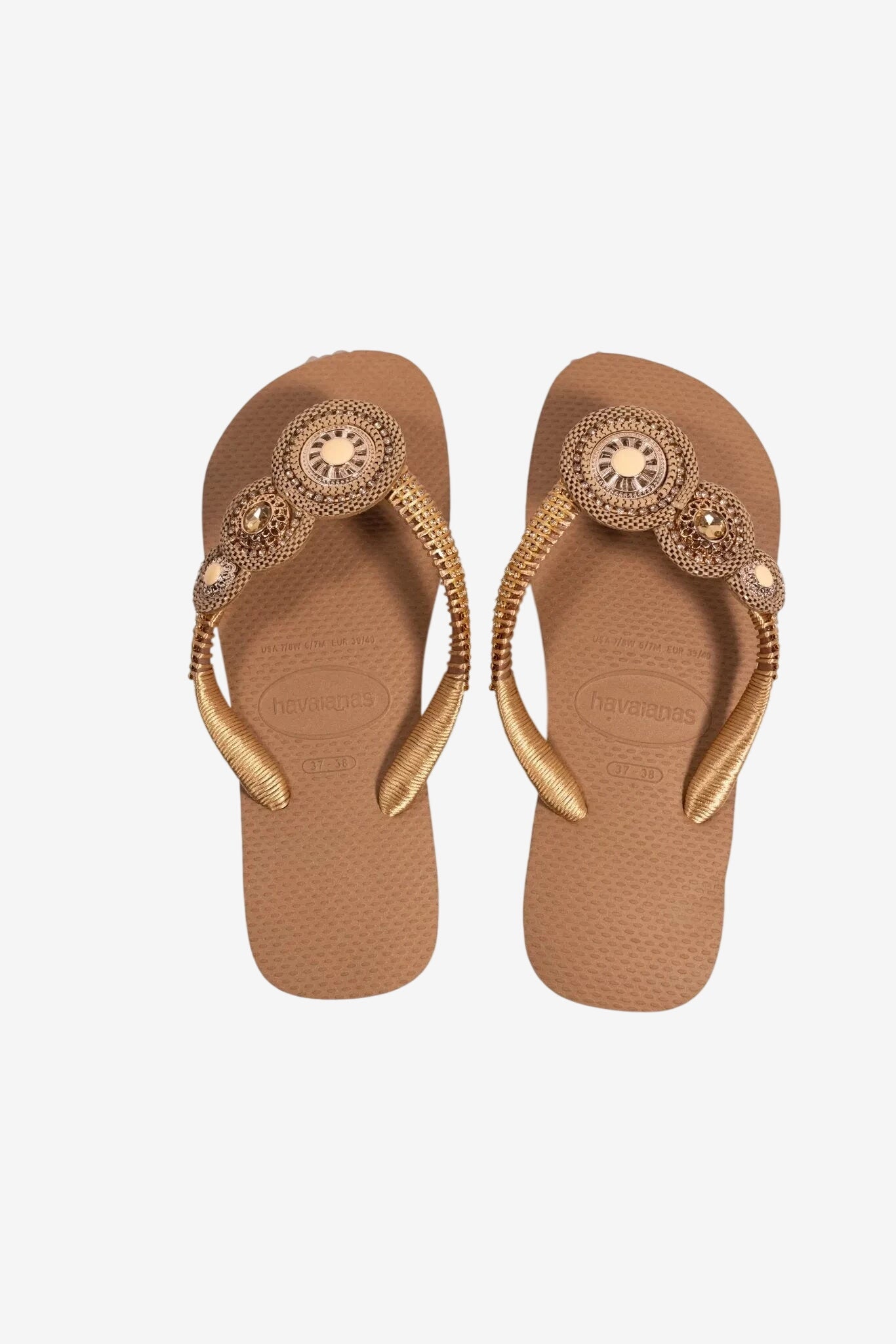 Infradito donna color beige con cinturini decorati da dettagli dorati e pietre luminose.