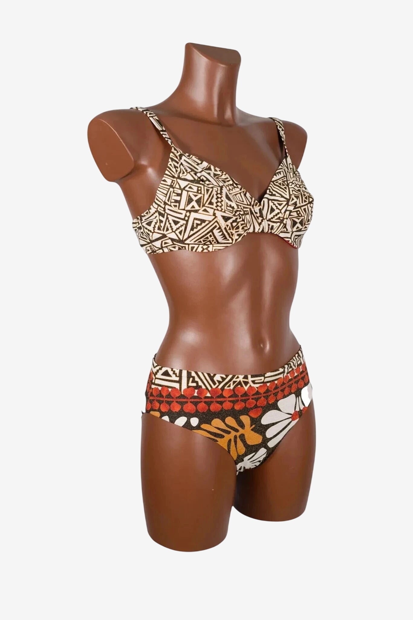 A two-piece bikini with a geometric print top and a floral patterned high-waisted bottom.
