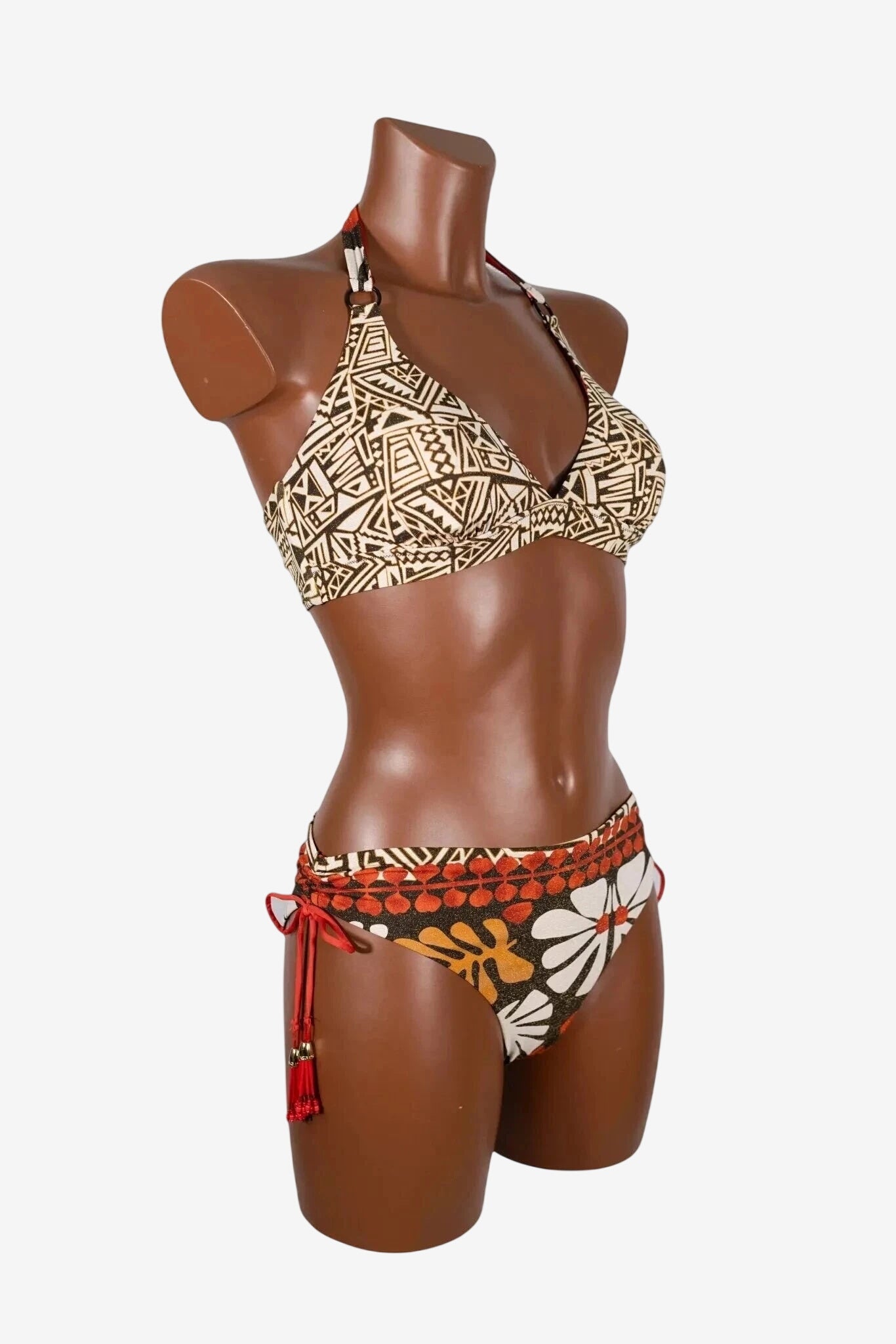 A mannequin wears a two-piece bikini with a geometric print top and a floral print bottom.
