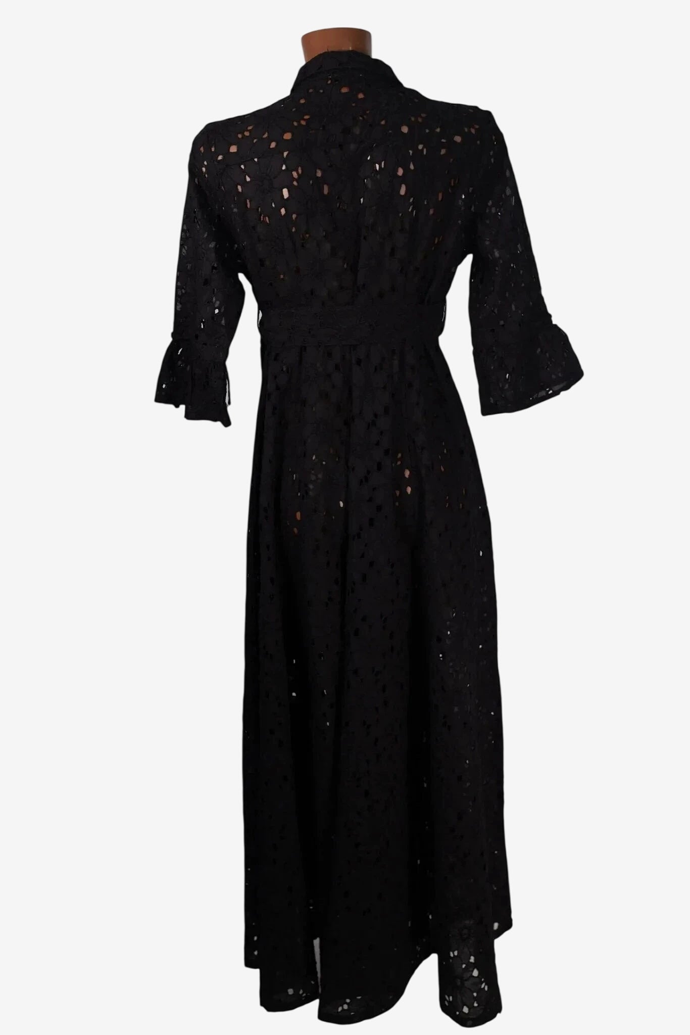 Une robe chemisier noire en dentelle ajourée avec des manches trois-quarts évasées.