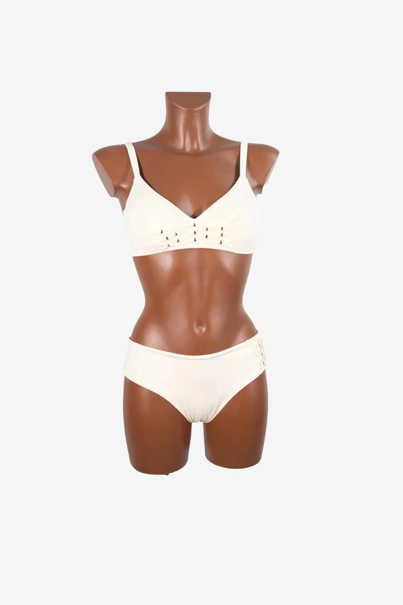 A cream-colored bralette bikini set featuring decorative lace-up detailing on the cups and sides.