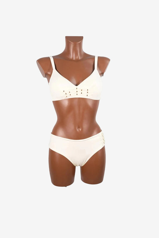 A cream-colored bralette bikini set featuring decorative lace-up detailing on the cups and sides.