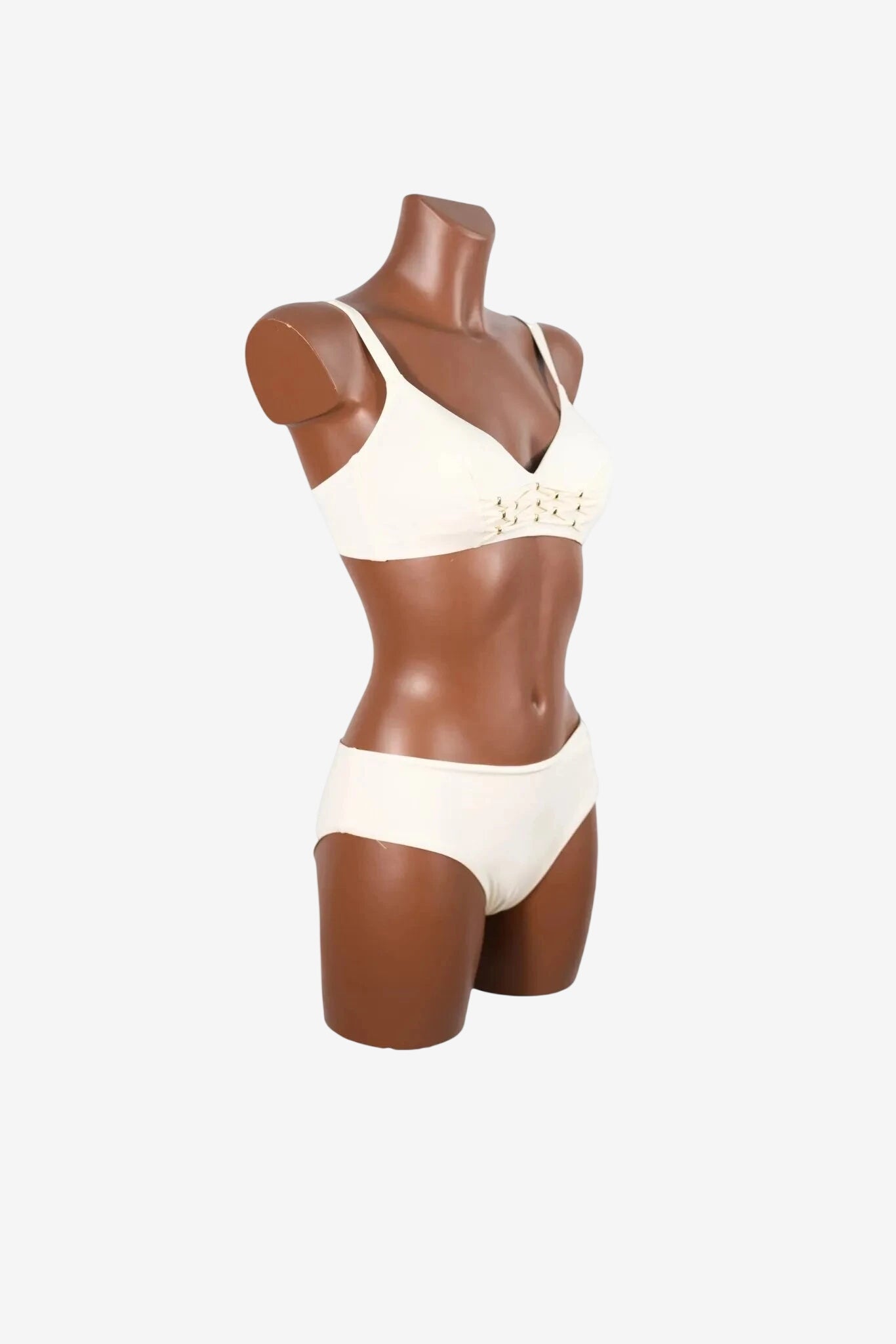 A cream-colored bralette with lace-up detailing on a mannequin torso.