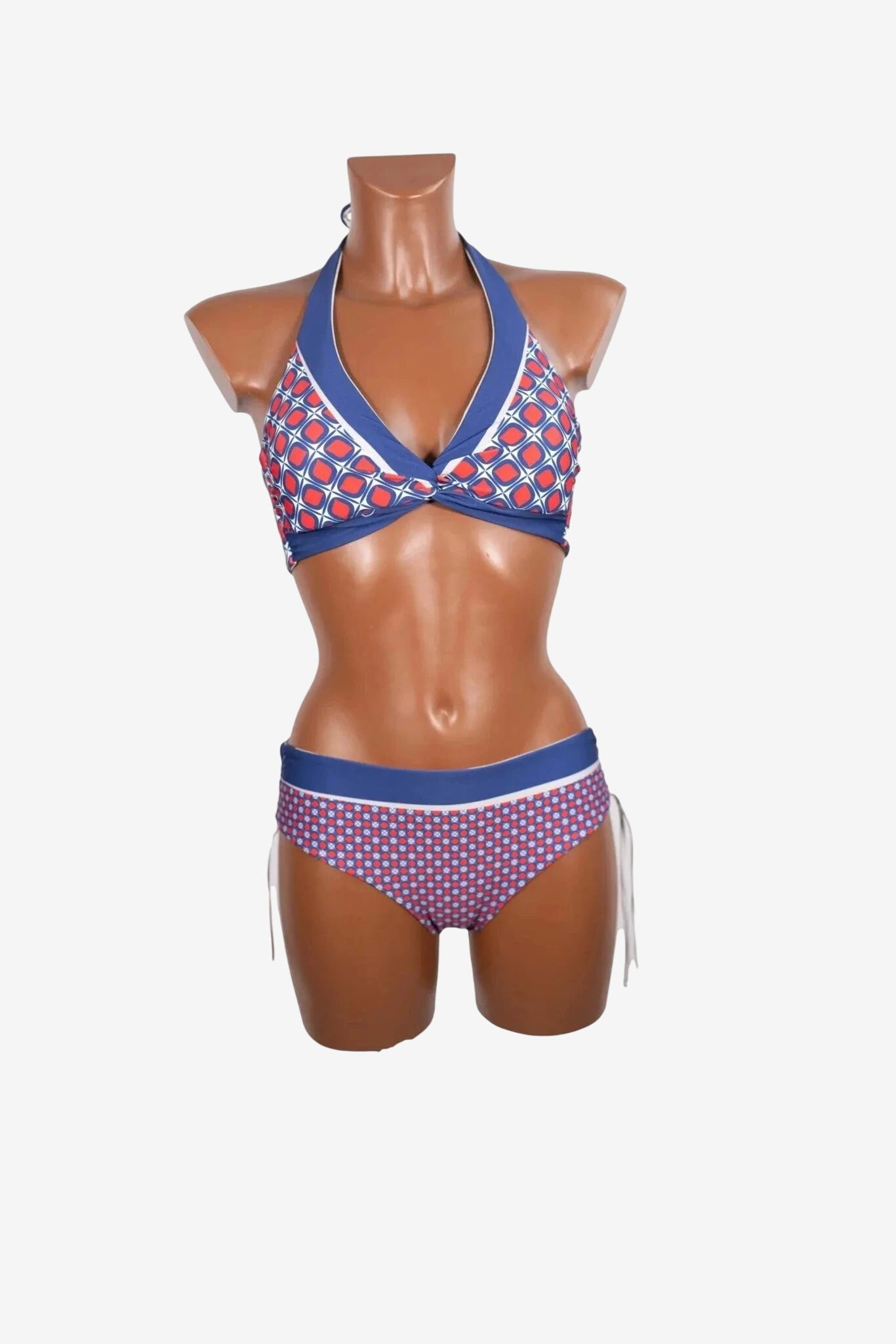 Bikini triangolare con stampa geometrica rossa e blu su un manichino.