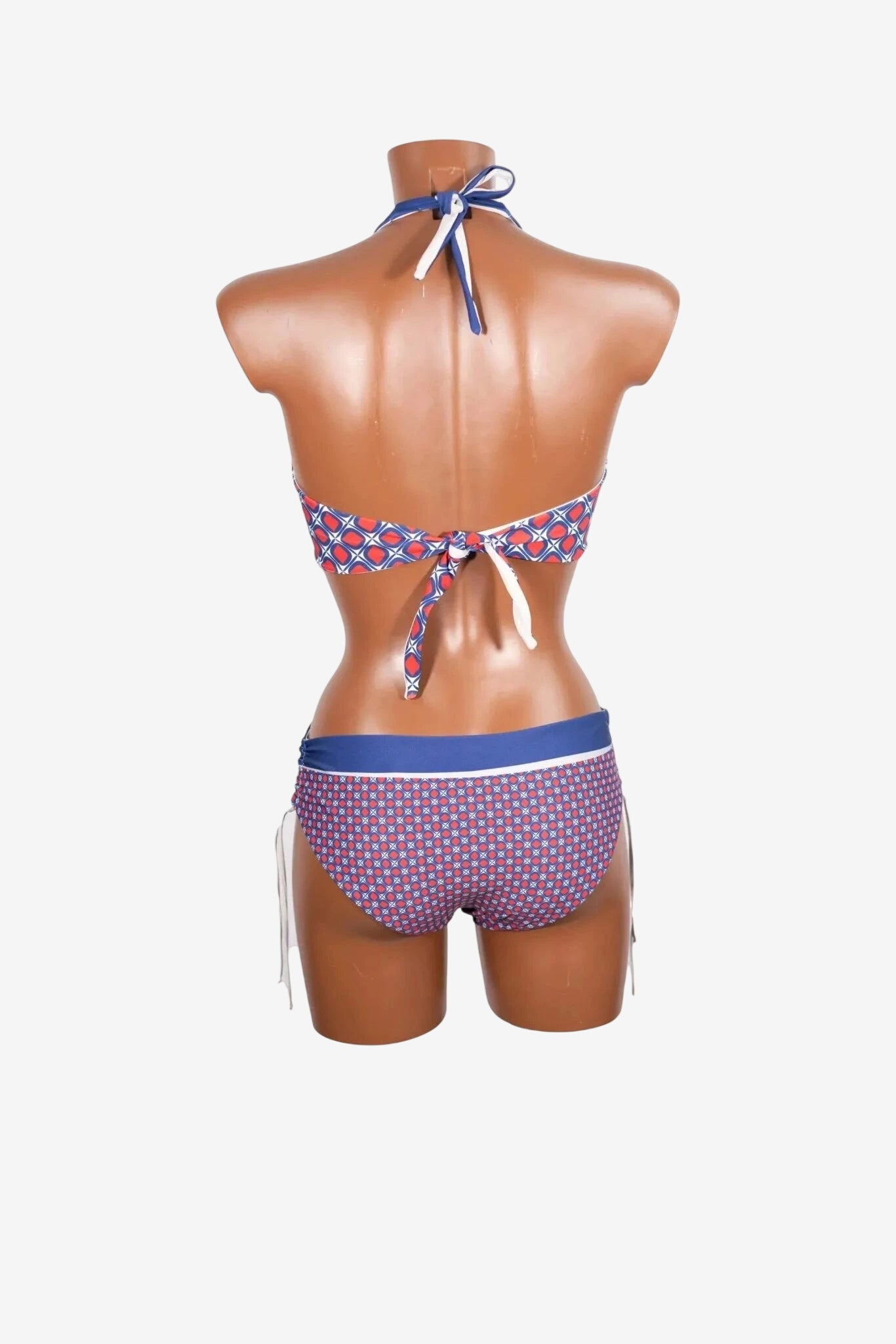 Bikini triangolare con stampa geometrica rossa e blu e dettagli a contrasto visto da dietro.