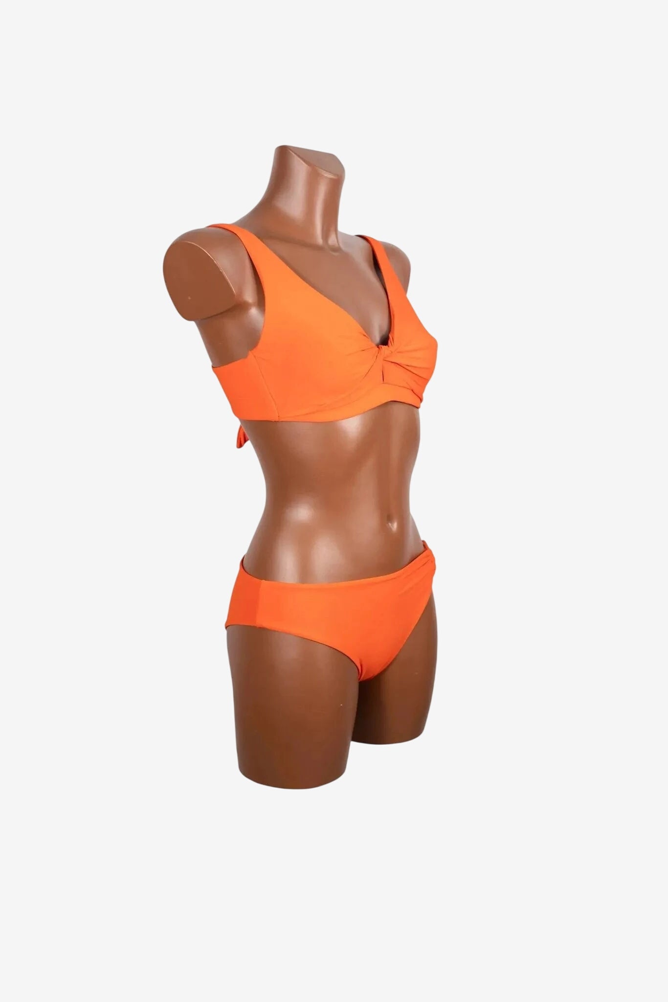 A bright orange two-piece bikini set displayed on a mannequin.
