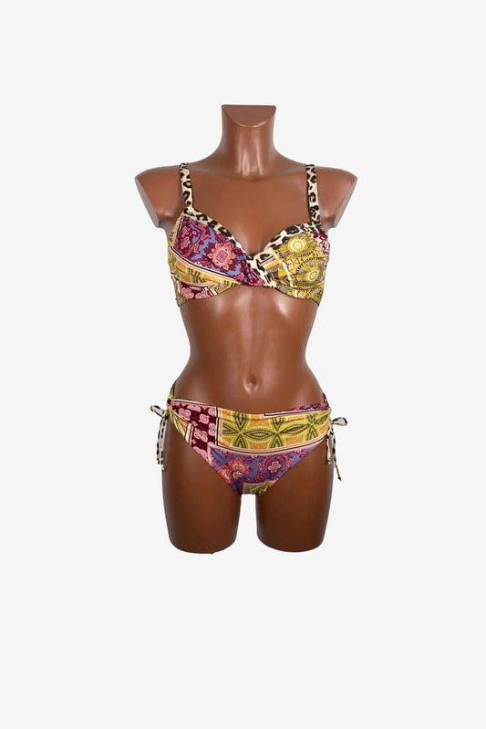 A patterned bikini set with a twisted underwire top and tie-side bottoms on a mannequin.