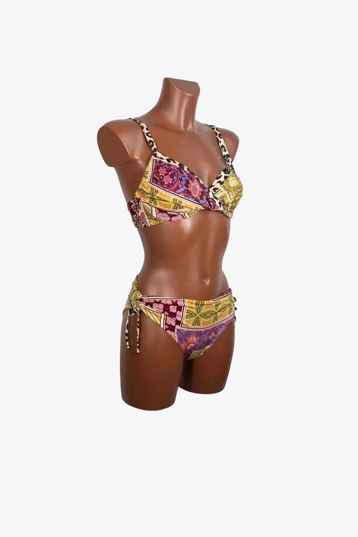 A two-piece bikini with a patterned design featuring floral and geometric motifs on a mannequin.