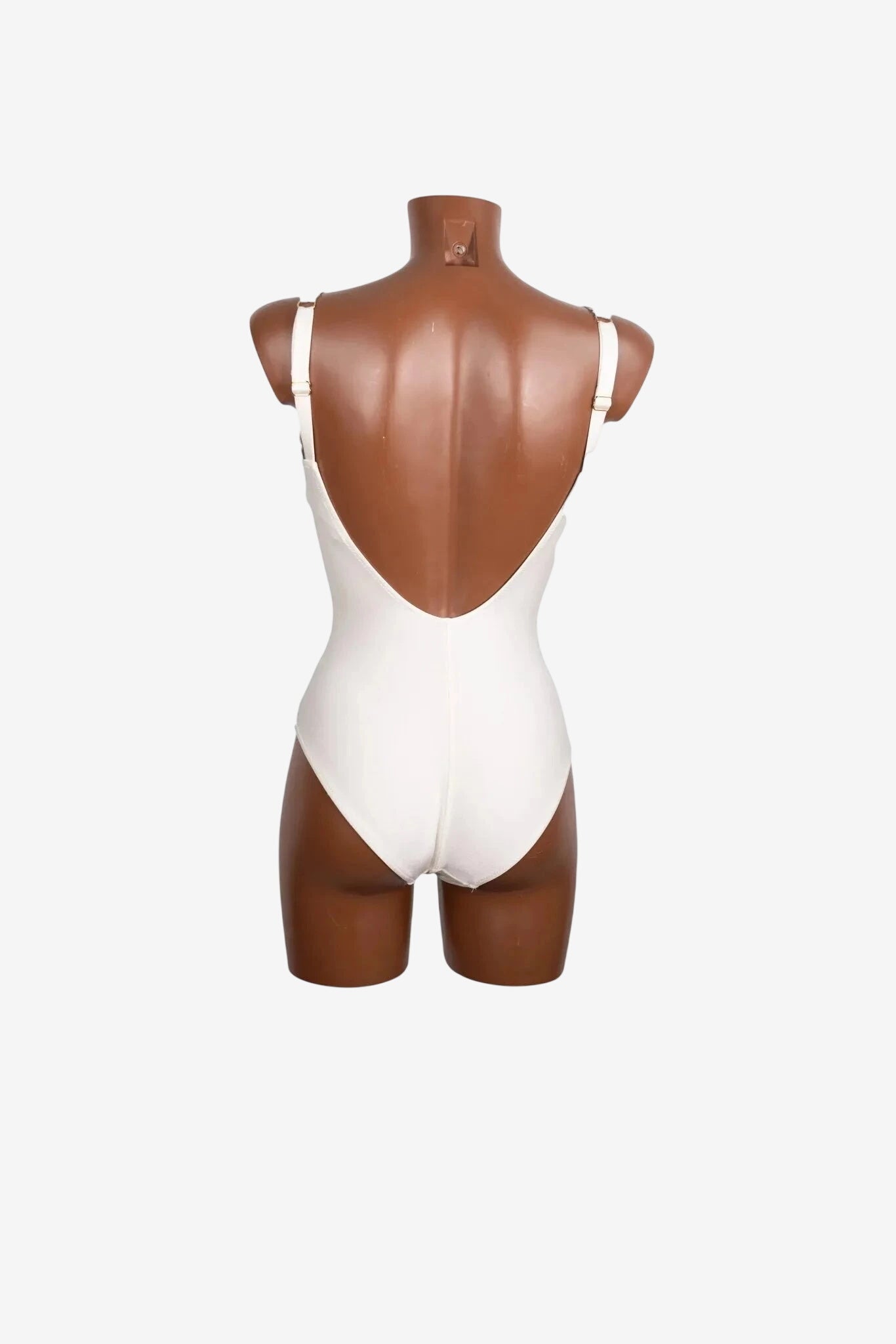 A white one-piece swimsuit with a deep scoop back displayed on a mannequin.