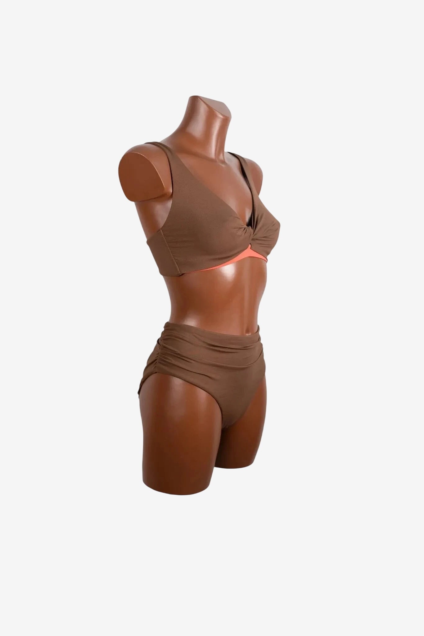 A brown two-piece bikini with a twisted top and high-waisted ruched bottoms on a mannequin.
